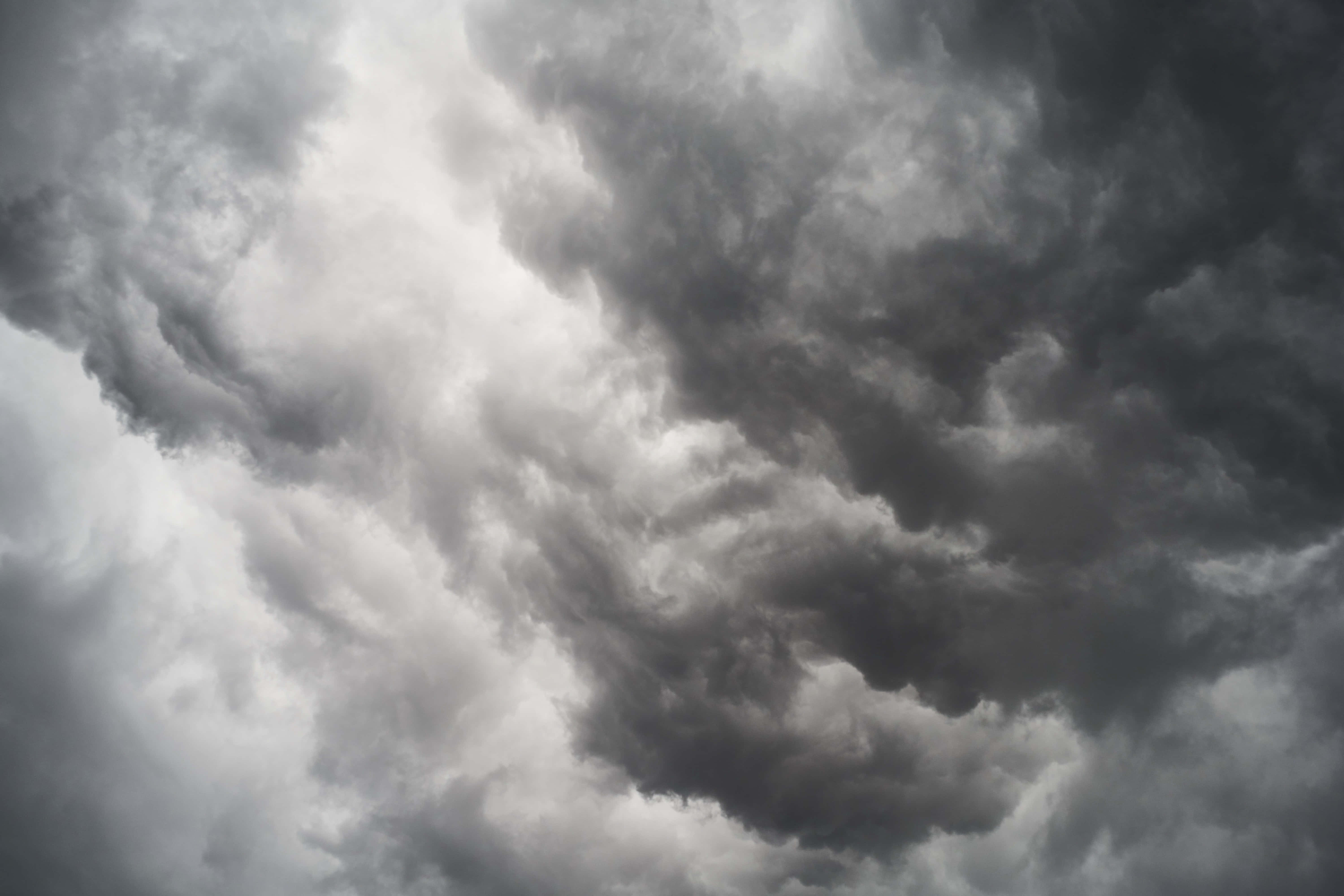 Dark Sky 桌布 壁紙 — 單色調的戲劇性旋轉風暴雲層，以不祥的紋理和深度充滿天空。
