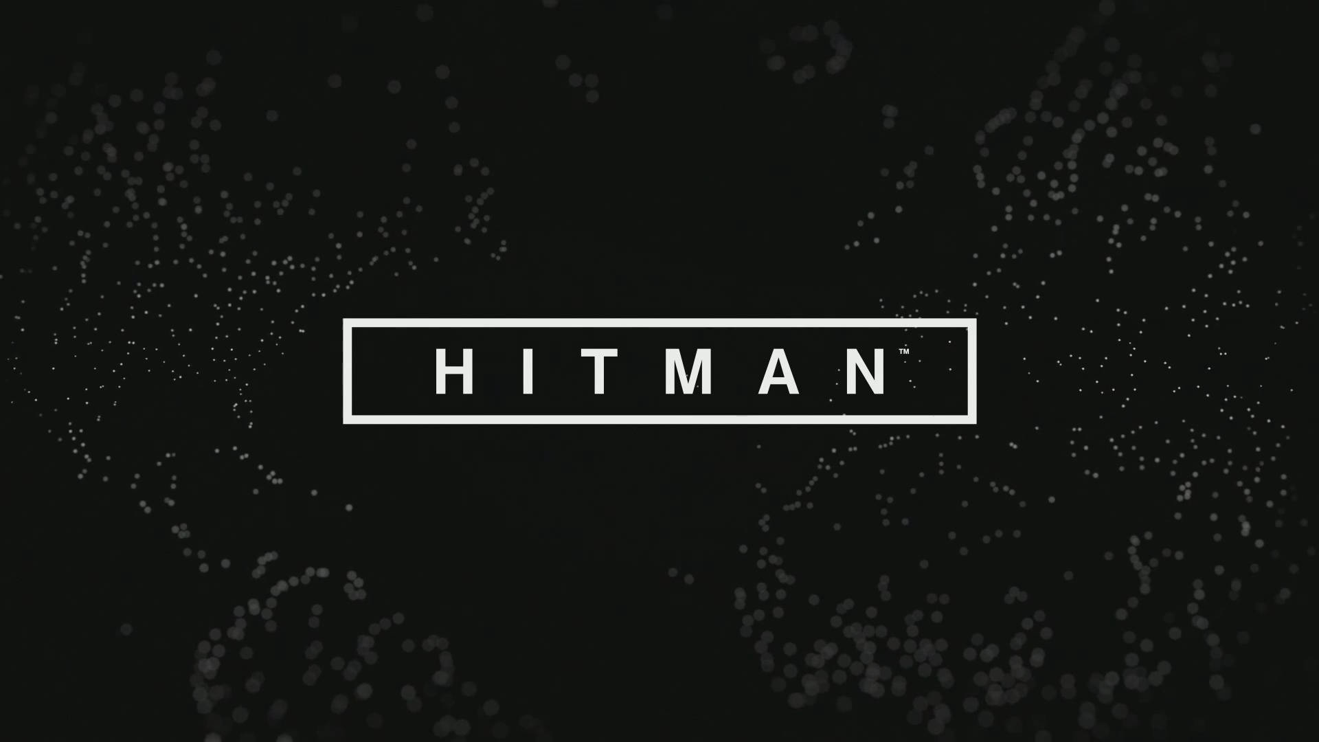 刺客教條 桌布 壁紙 — 單詞 HITMAN 以粗體白色字母顯示在矩形內，背景為黑色，帶有散落的發光粒子。