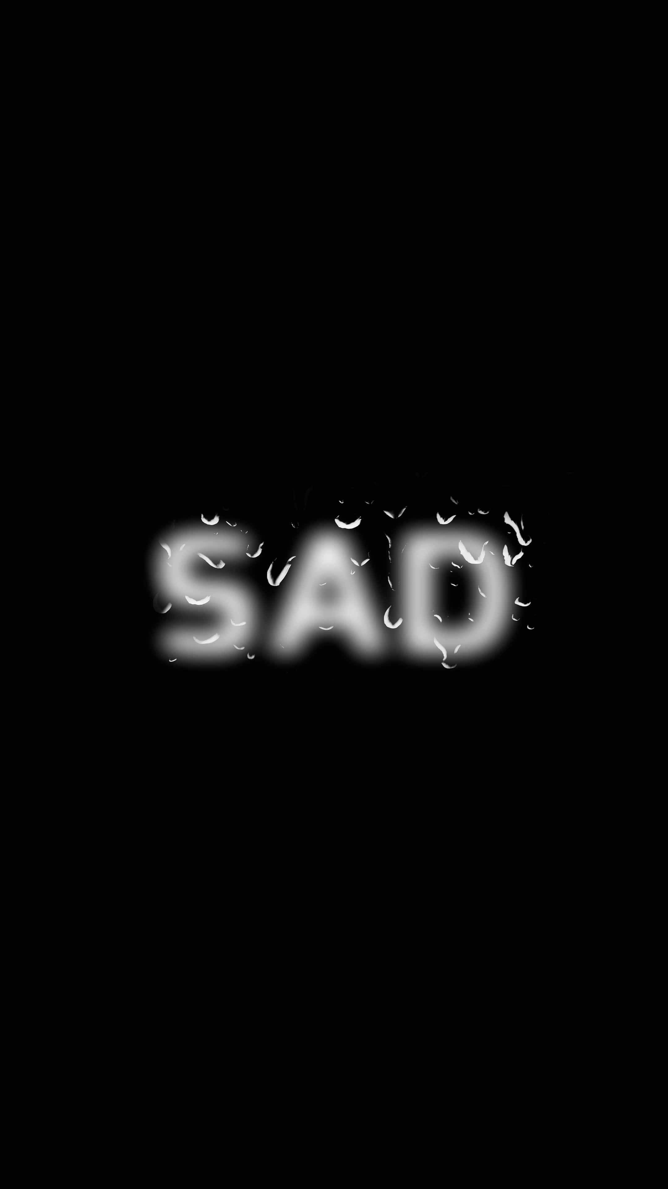 Black Sad 桌布 壁紙 — 單詞 sad 在黑色背景上微弱地發出白色光芒，水滴附著在其字母上。