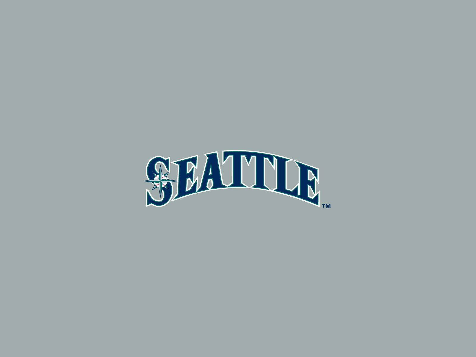 Team 桌布 壁紙 — 單詞「SEATTLE」以粗體藍色拱形字體呈現，S 內有指南針玫瑰，居中於純灰色背景上。
