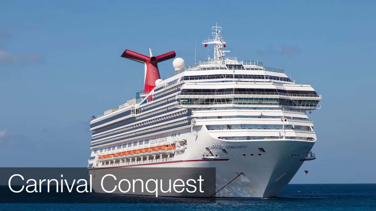 Carnival Conquest 桌布 壁紙 — 嘉年華征服號郵輪在晴朗的藍天下，在平靜的碧綠海面上雄偉地航行。