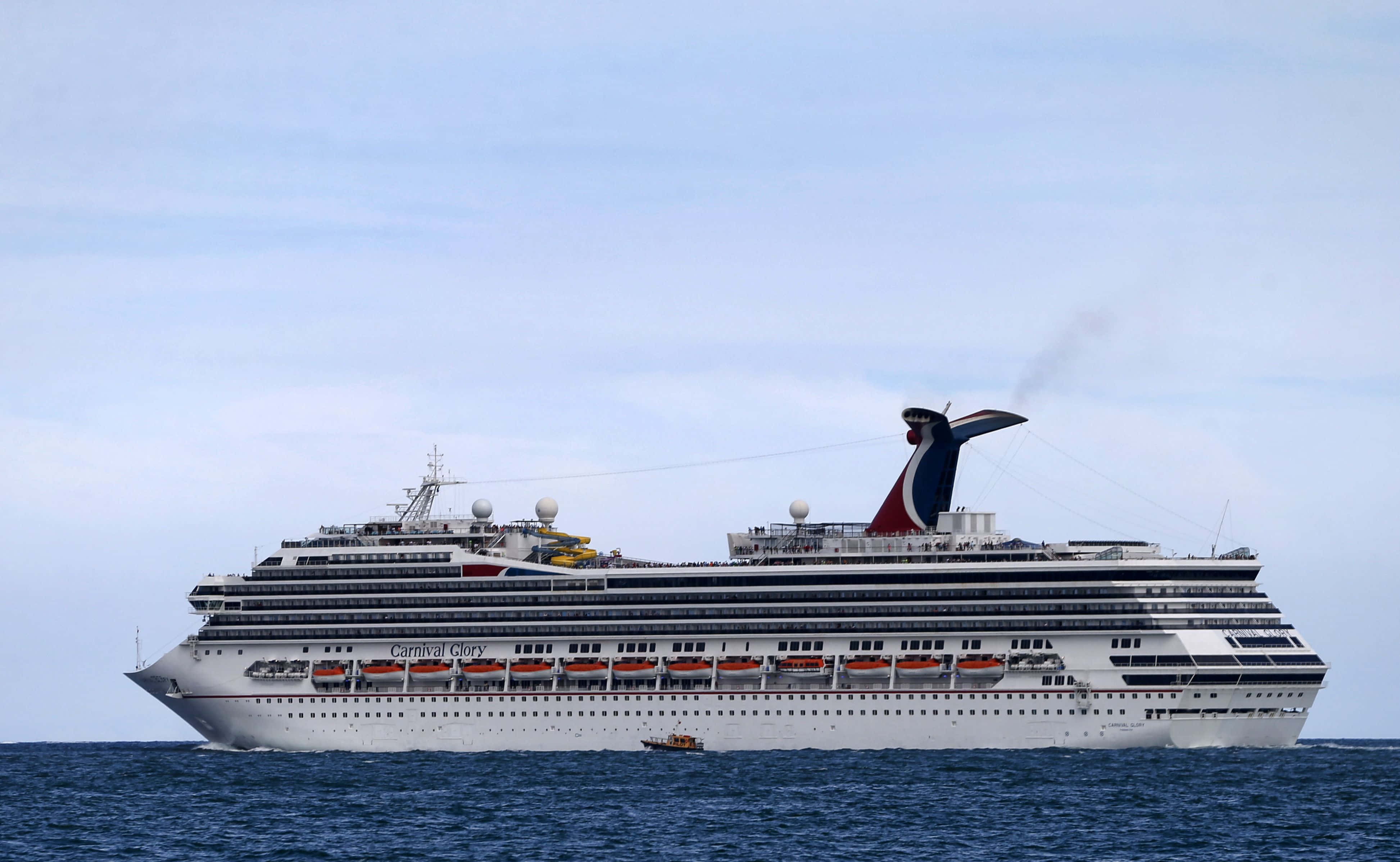 Carnival Dream 桌布 壁紙 — 嘉年華榮耀號郵輪在柔和的多雲天空下，雄偉地航行在平靜的藍色水域上。