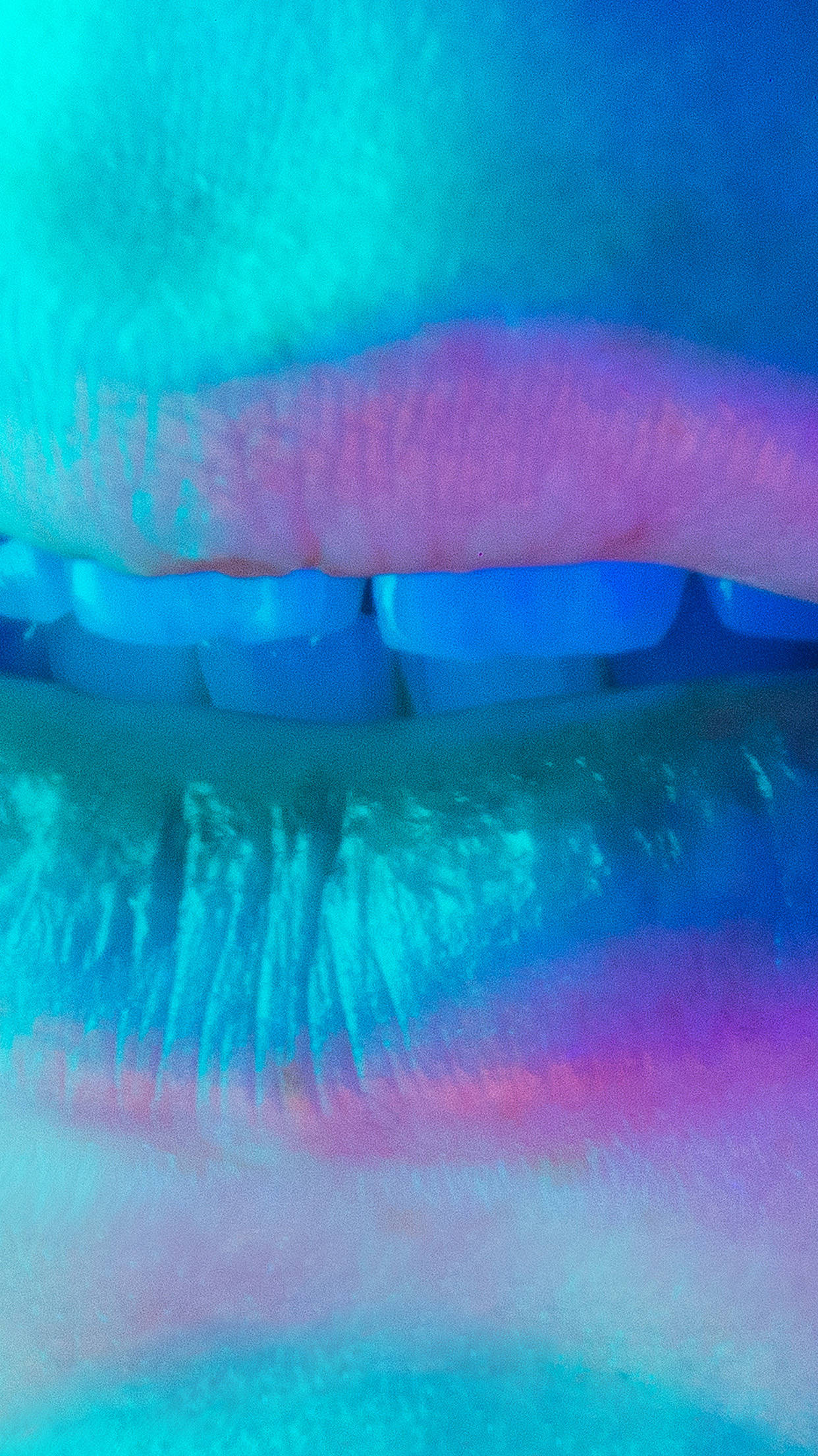 pout 桌布 壁紙 — 嘴唇和牙齒的特寫，沐浴在充滿活力的藍色和粉紅色霓虹燈光中，帶有光澤質感。