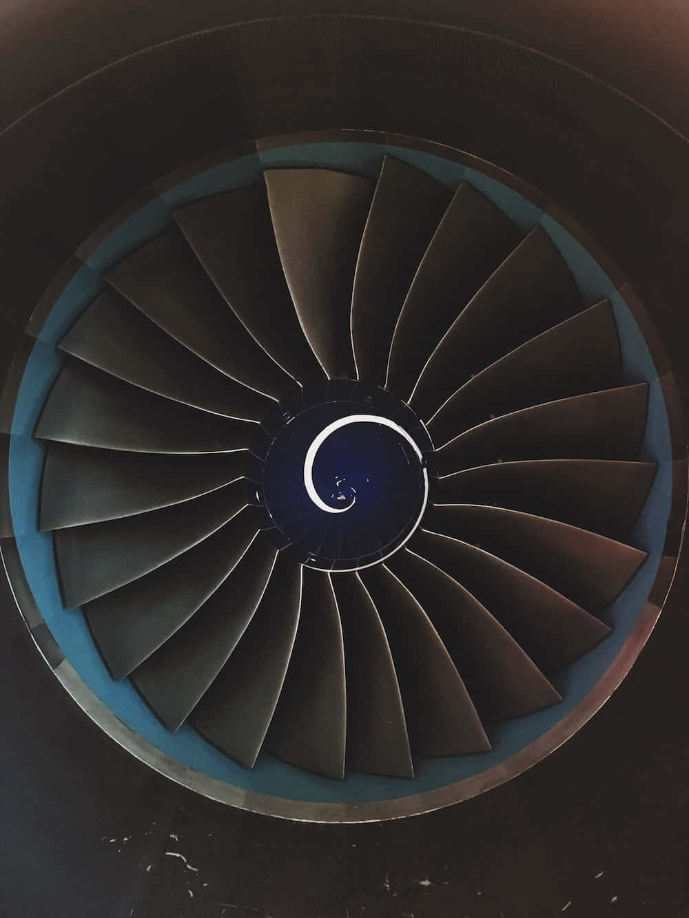 Jet Engine 桌布 壁紙 — 噴射引擎渦輪的近距離視圖，深色葉片從發光的藍色中心輻射出來。