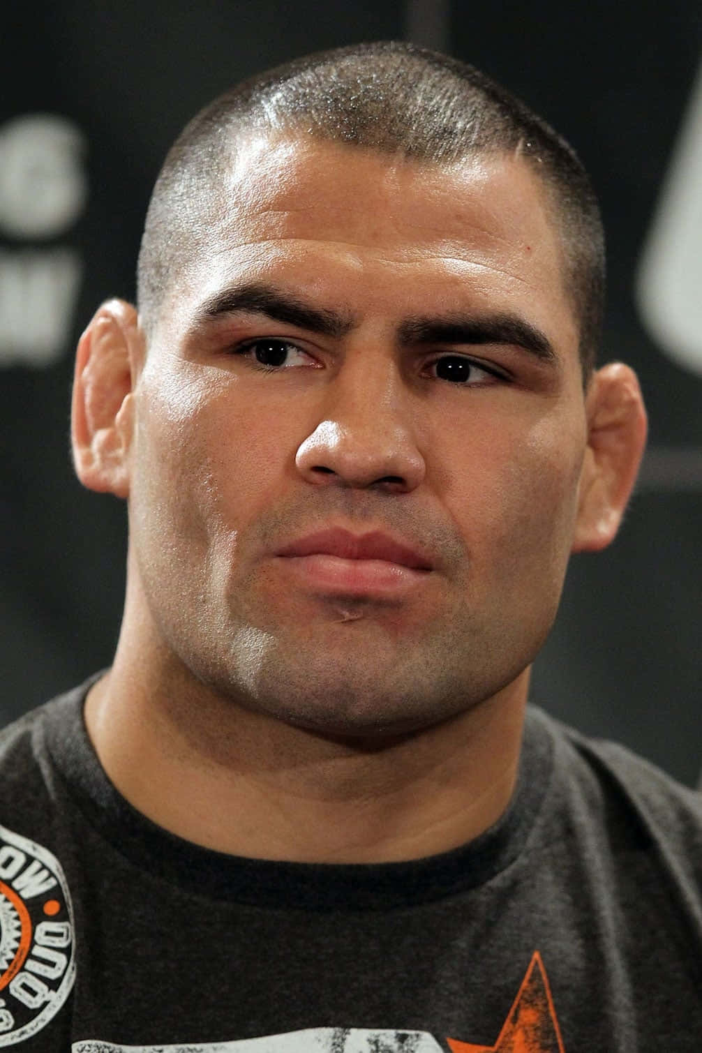 UFC 桌布 壁紙 — 嚴肅男性拳手短黑髮穿深色T恤的頭像特寫，背景模糊。