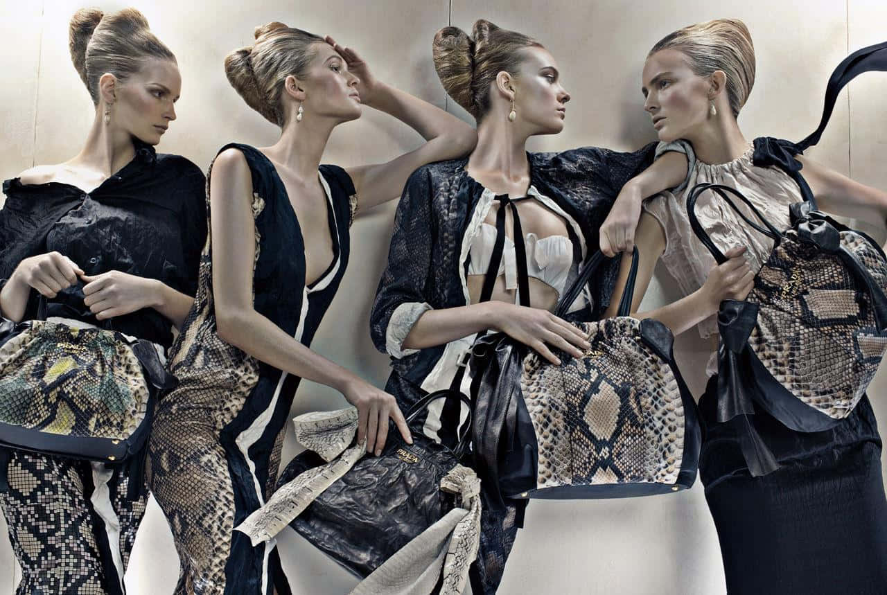 Prada 桌布 壁紙 — 四位優雅模特兒身穿黑色及蛇皮服裝，在簡約米色牆前手持奢華手袋擺姿勢。