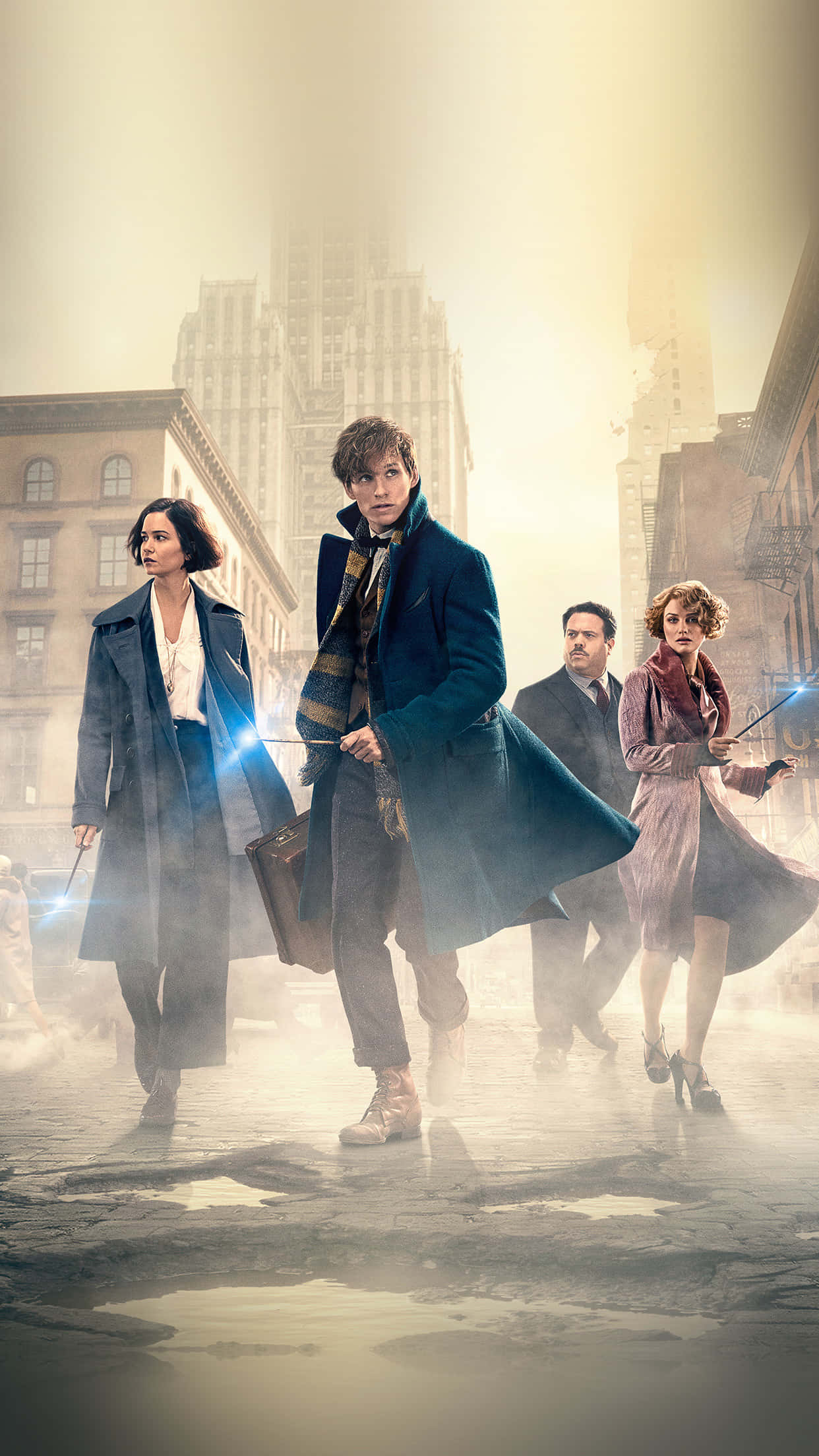 Fantastic Beasts 桌布 壁紙 — 四位巫師在金色陽光下，手持發光魔杖，大步穿過煙霧瀰漫的城市街道。