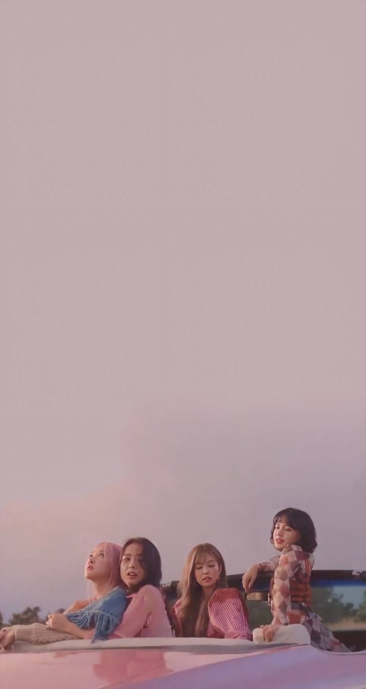BLACKPINK 桌布 壁紙 — 四位年輕女性在柔和的粉紅色暮色天空下，放鬆地坐在汽車車頂上。