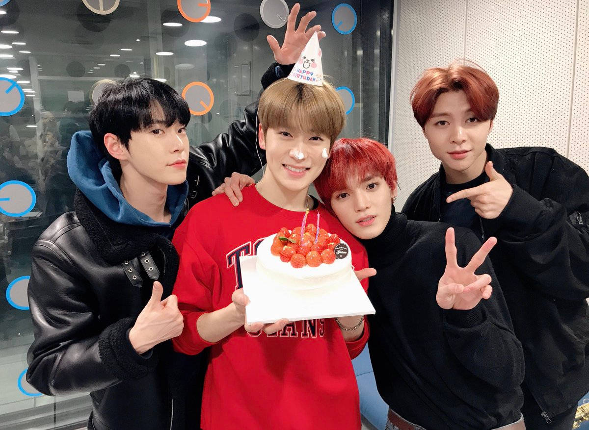 Nct 桌布 壁紙 — 四位年輕男士在現代辦公室環境中，用櫻桃蛋糕和派對帽慶祝。