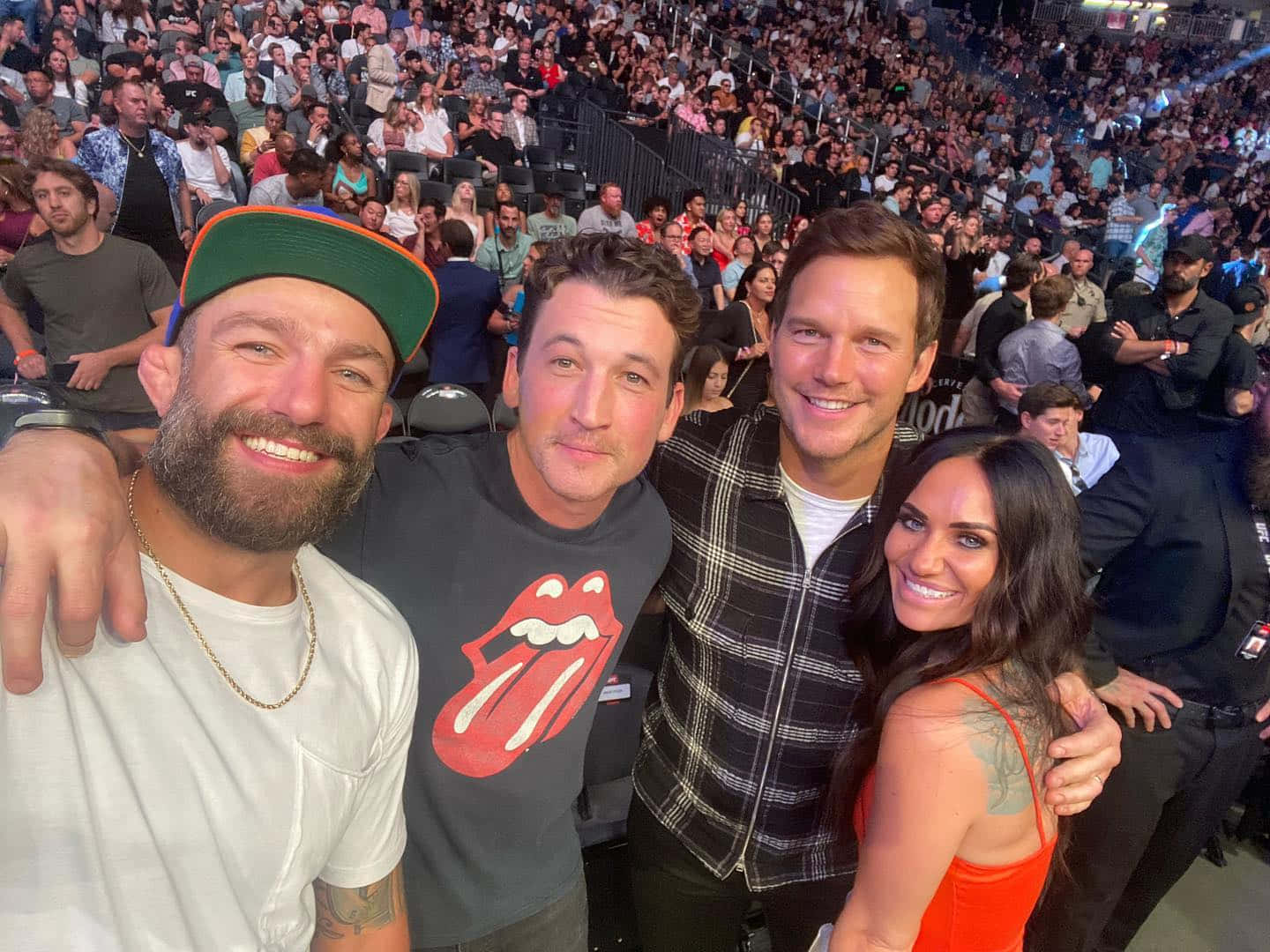 UFC 桌布 壁紙 — 四位微笑的名人在擠滿觀眾的音樂會場地自拍，背景有粉絲。