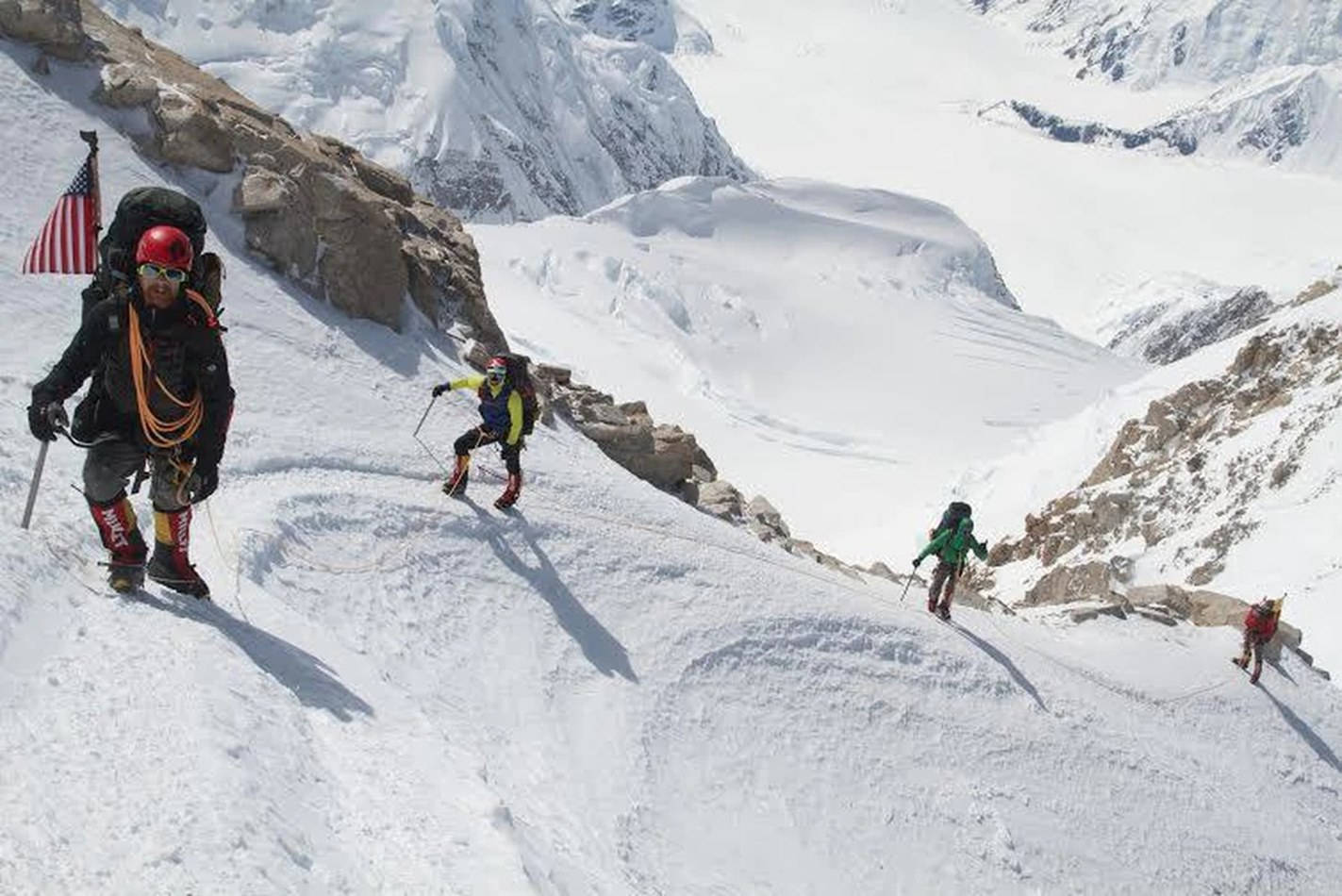 Climbing 桌布 壁紙 — 四位攀山者在明亮的日光下，用冰斧和繩索攀登陡峭的雪山斜坡。