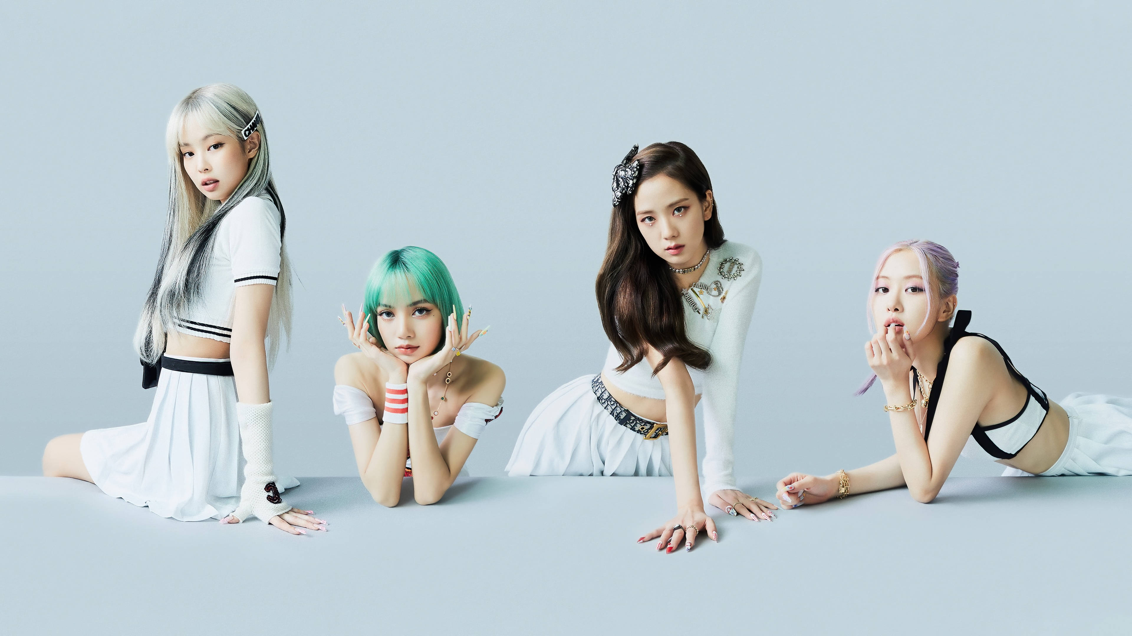 BLACKPINK 桌布 壁紙 — 四位時尚女性，擁有色彩繽紛的頭髮，穿著白色服裝，在柔和的灰色工作室背景下自信地擺姿勢。