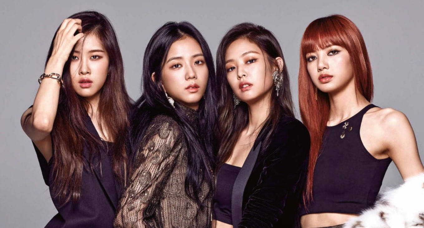 BLACKPINK 桌布 壁紙 — 四位時尚女性，擁有鮮豔的髮色和時尚的黑色服裝，在純灰色工作室背景前自信地擺姿勢。
