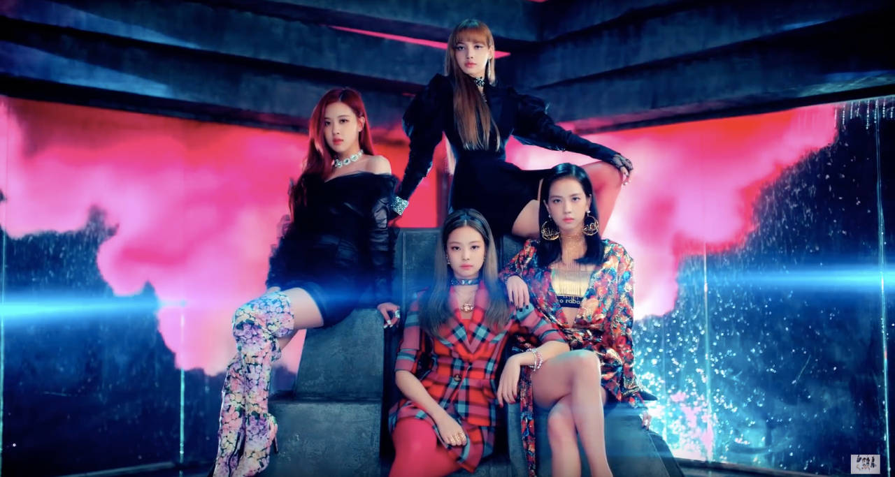 BLACKPINK 桌布 壁紙 — 四位時尚女性在未來風格的平台上戲劇性地擺姿勢，背景是發光的粉紅和藍色霓虹燈。