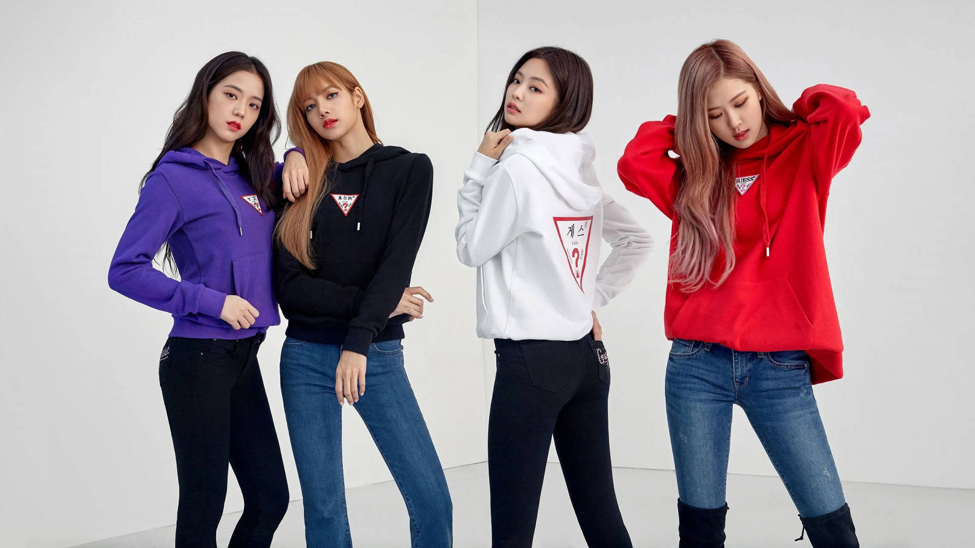 BLACKPINK 桌布 壁紙 — 四位時尚女性在純白工作室背景下自信地穿著彩色連帽衫擺姿勢。