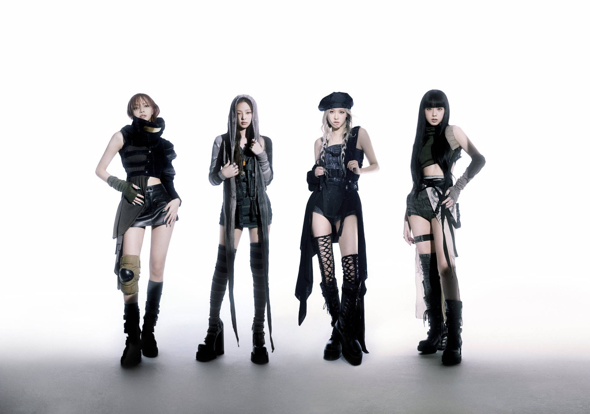 BLACKPINK 桌布 壁紙 — 四位時尚女性穿著前衛黑色服裝，在純白工作室背景前自信擺姿勢。
