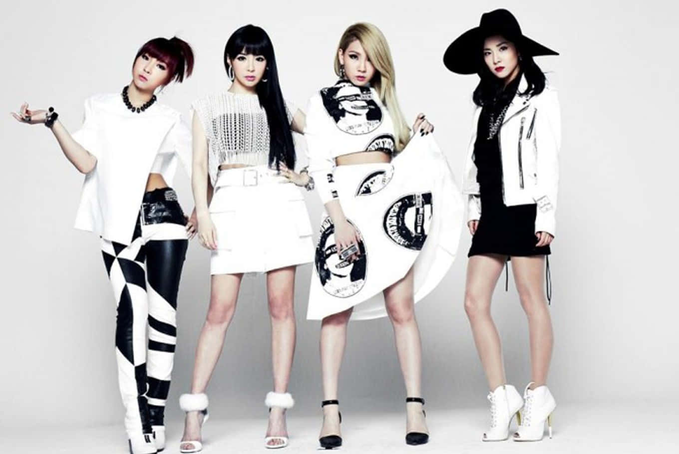 2NE1 桌布 壁紙 — 四位時尚女性穿著大膽的黑白服裝，在純白色工作室背景前自信地擺姿勢。