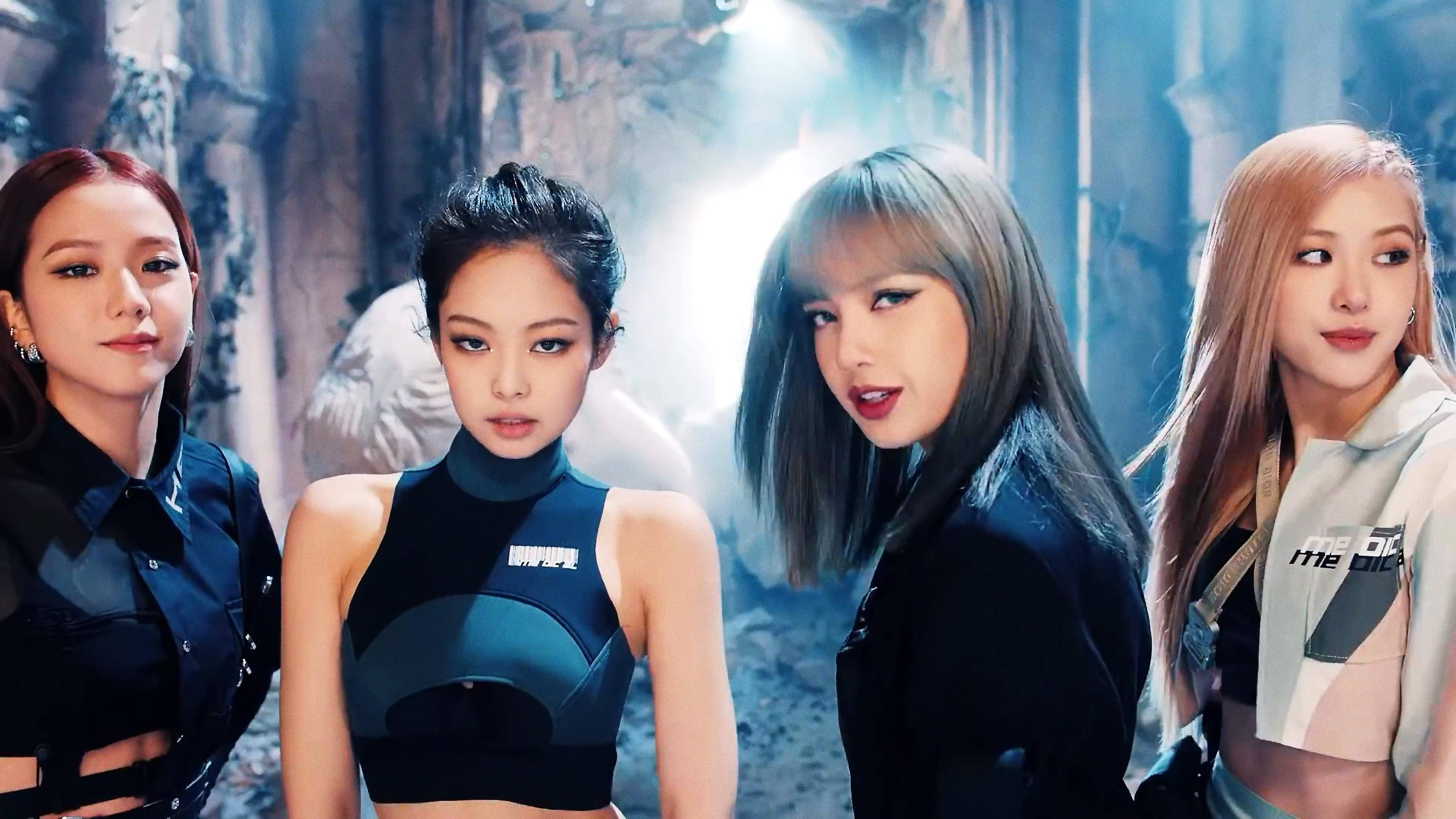 BLACKPINK 桌布 壁紙 — 四位時尚女性穿著深色未來主義服裝，在煙霧瀰漫的廢棄城市小巷中，在戲劇性的燈光下自信地擺姿勢。