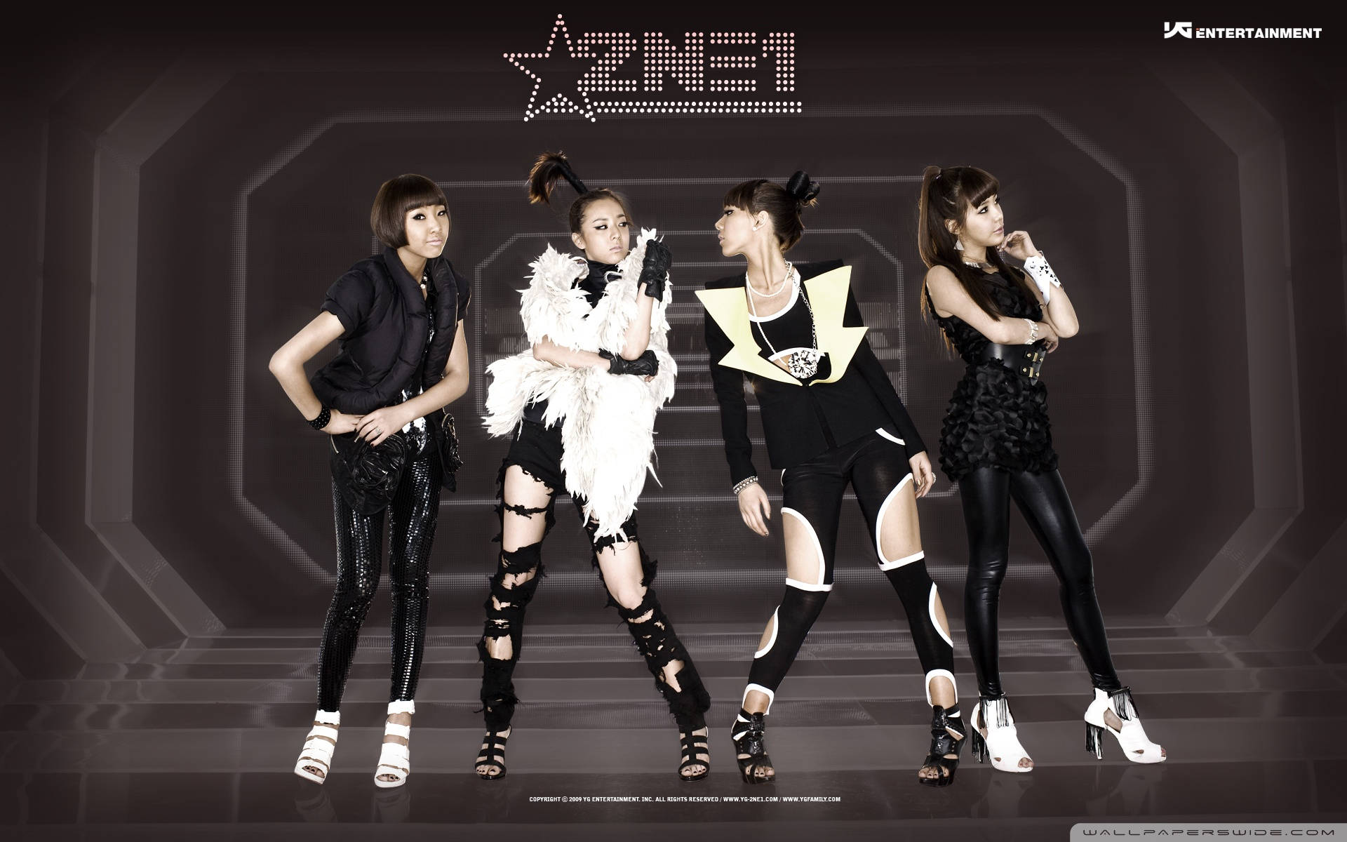 2ne1 桌布 壁紙 — 四位時尚女表演者穿著大膽的黑白服裝，在未來感的幾何隧道中自信地擺姿勢。