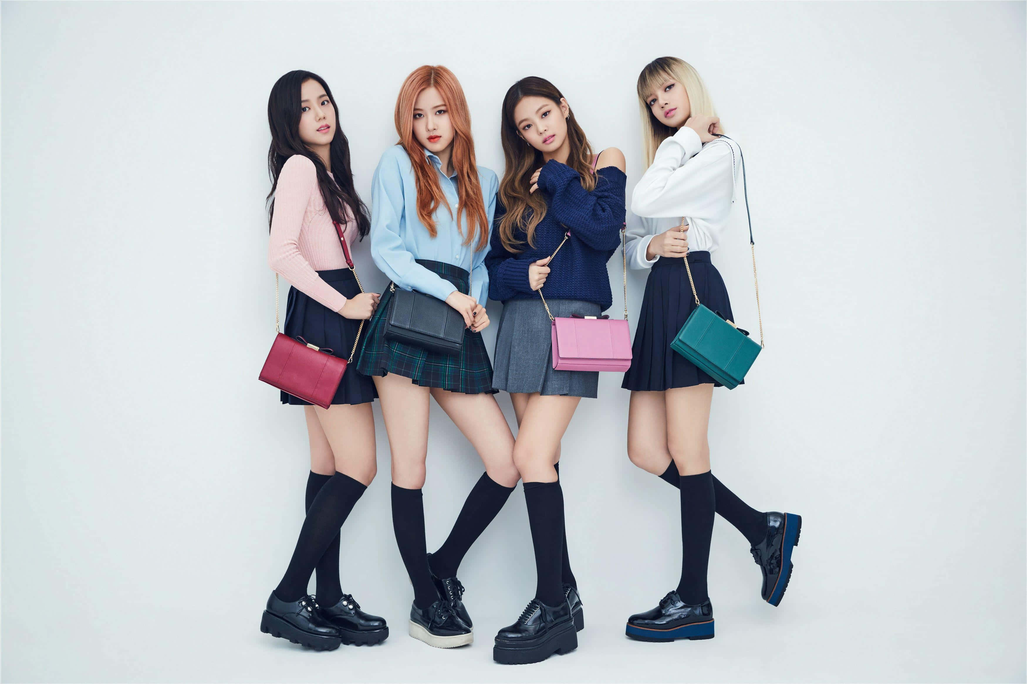 BLACKPINK 桌布 壁紙 — 四位時尚年輕女性穿著協調的校服，在純白背景前自信地擺姿勢。