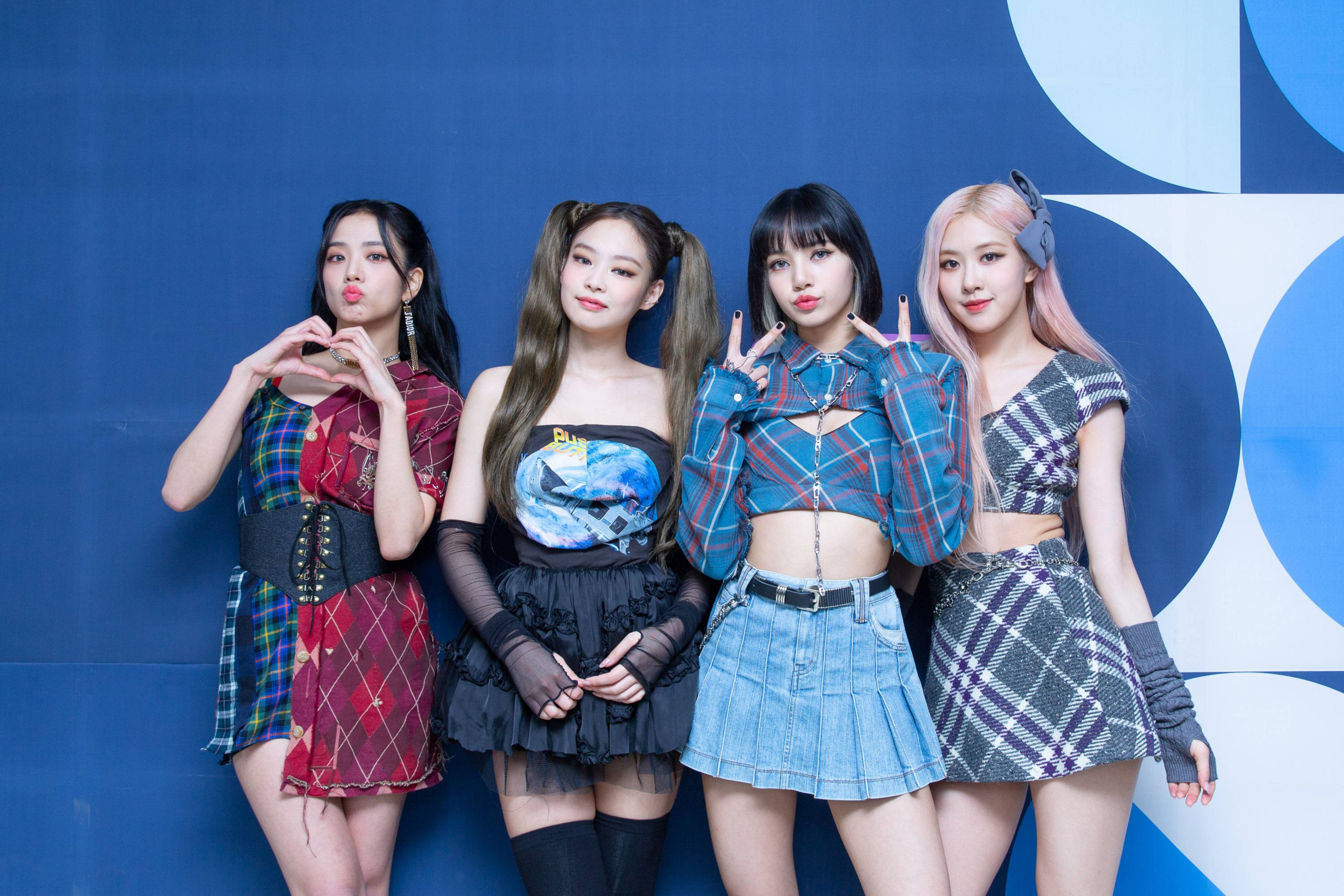 BLACKPINK 桌布 壁紙 — 四位時尚的K-pop偶像在搶眼的藍色幾何牆前自信地擺出格紋裝扮的姿勢。