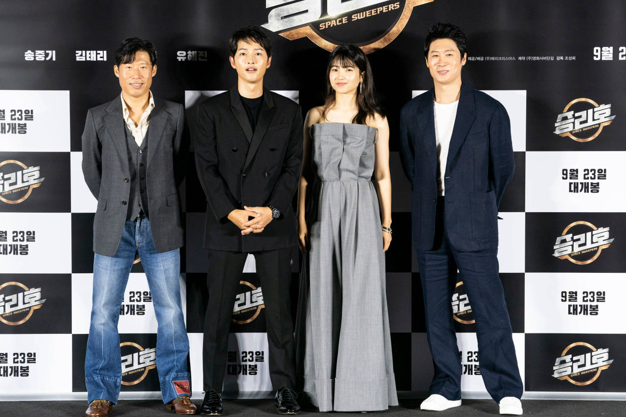 Space Sweepers 桌布 壁紙 — 四位演員在電影首映會上正式擺姿勢，背景為格子圖案，帶有韓文文字和片名《Space Sweepers》。