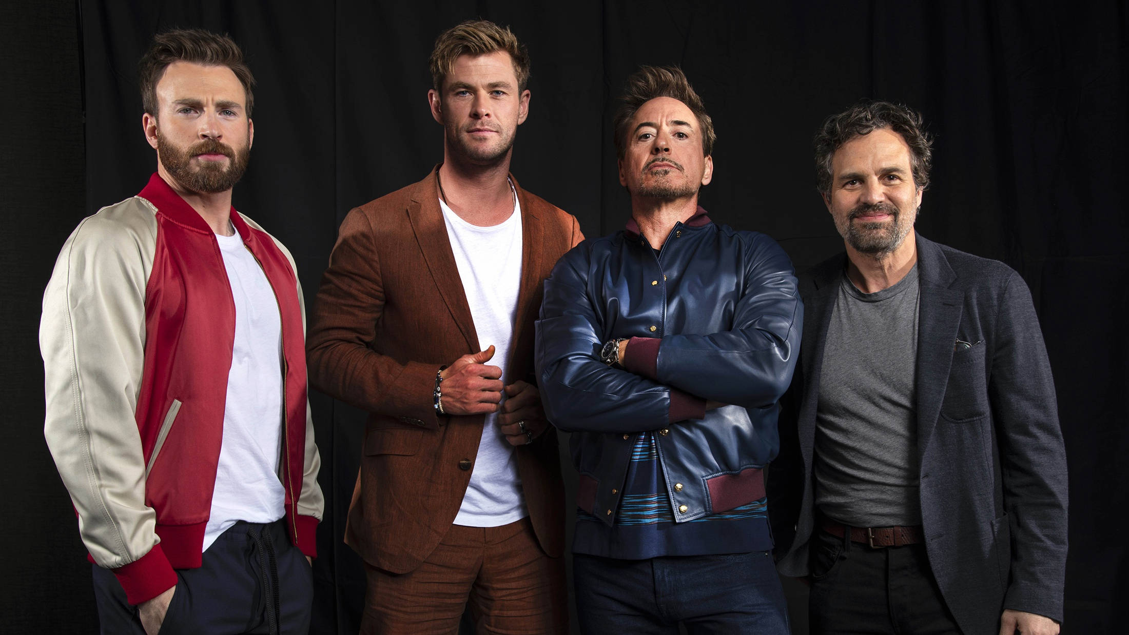 Mark Ruffalo 桌布 壁紙 — 四位男演員在黑色背景下自信地擺姿勢，穿著休閒時尚的服裝。