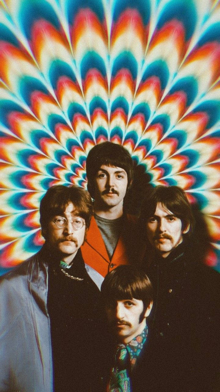 the beatles 桌布 壁紙 — 四位留鬍鬚、身穿1960年代時尚的男士，站在迷幻彩虹曼陀羅背景前。