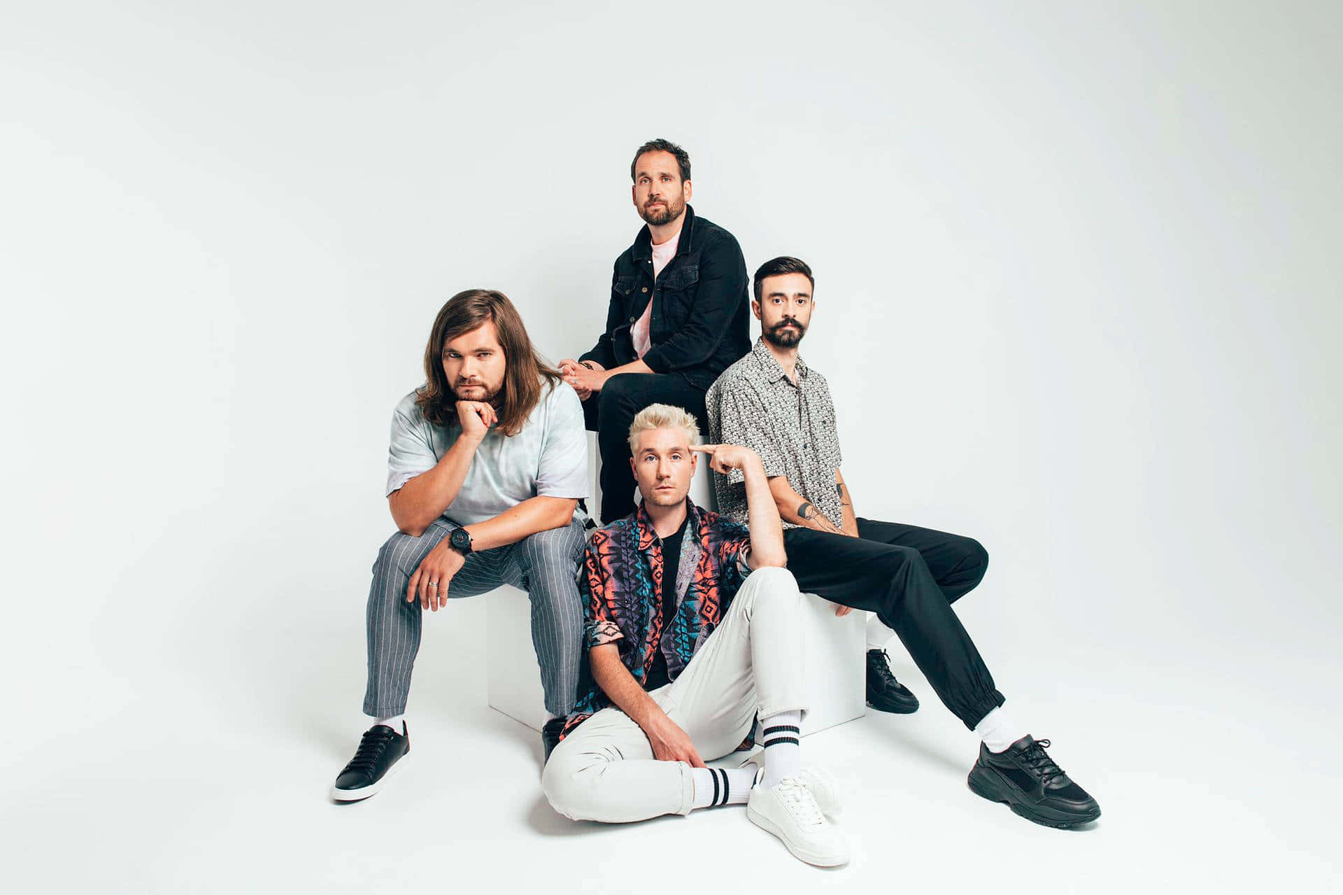 Bastille 桌布 壁紙 — 四位留鬍鬚的時尚男士自信地站在白色立方體上，背景是純白色的攝影棚。