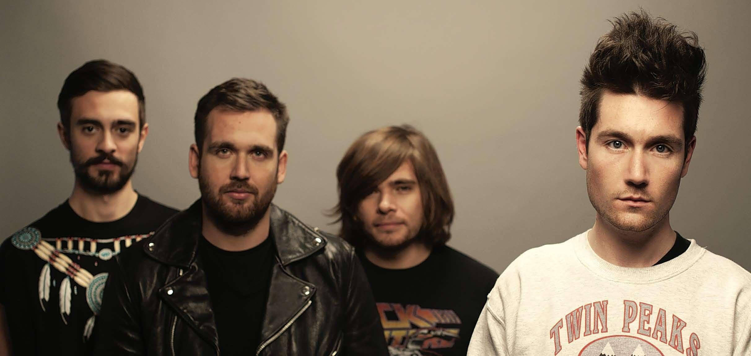 Bastille 桌布 壁紙 — 四位眼神銳利、時尚前衛的男士在純灰色攝影棚背景前擺姿勢。