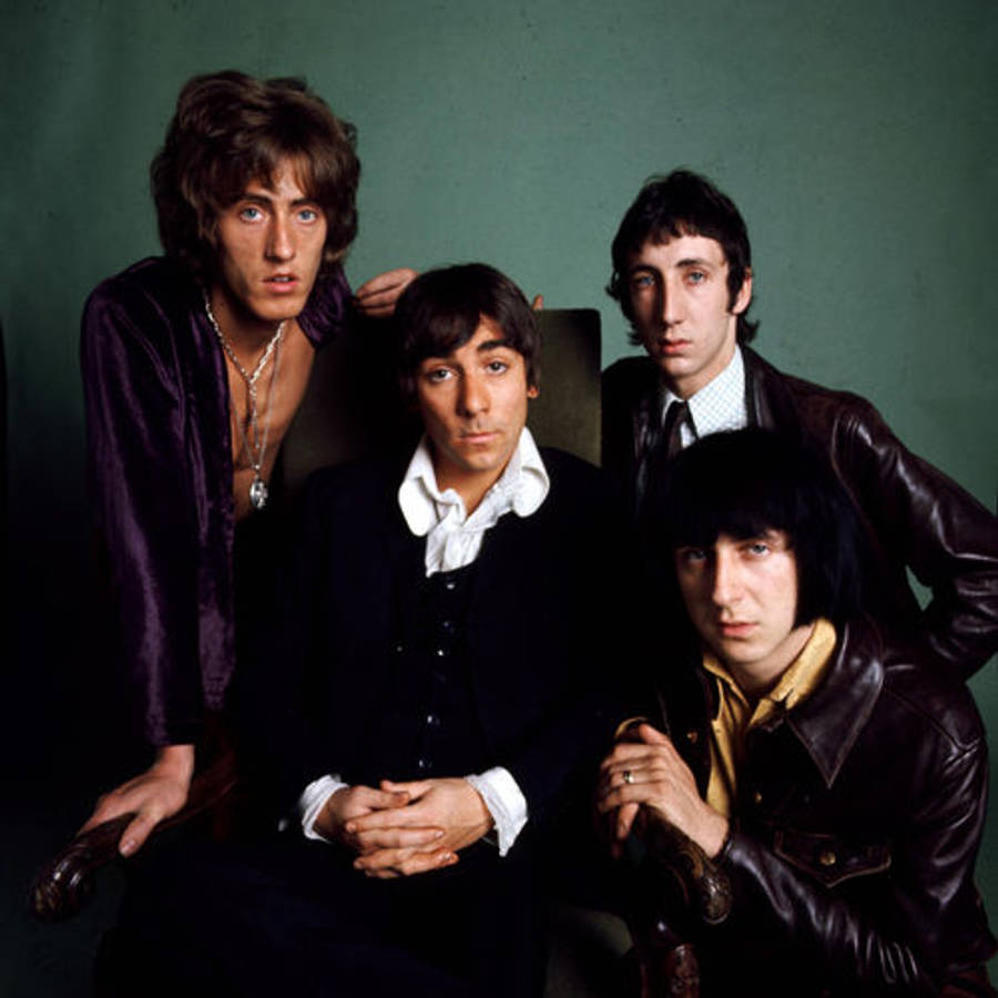 Rock 桌布 壁紙 — 四位穿著1970年代時尚的男士，在柔和的綠色背景前，穿著皮夾克和天鵝絨質感，嚴肅地擺姿勢。