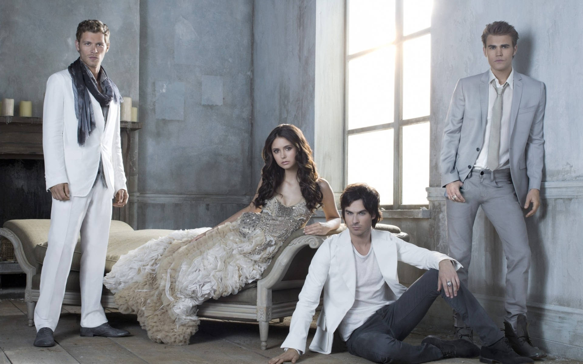 Vampire Diaries 桌布 壁紙 — 四位穿著時尚的人士在一個陽光普照、質樸的石室中戲劇性地擺姿勢，室內有復古家具。