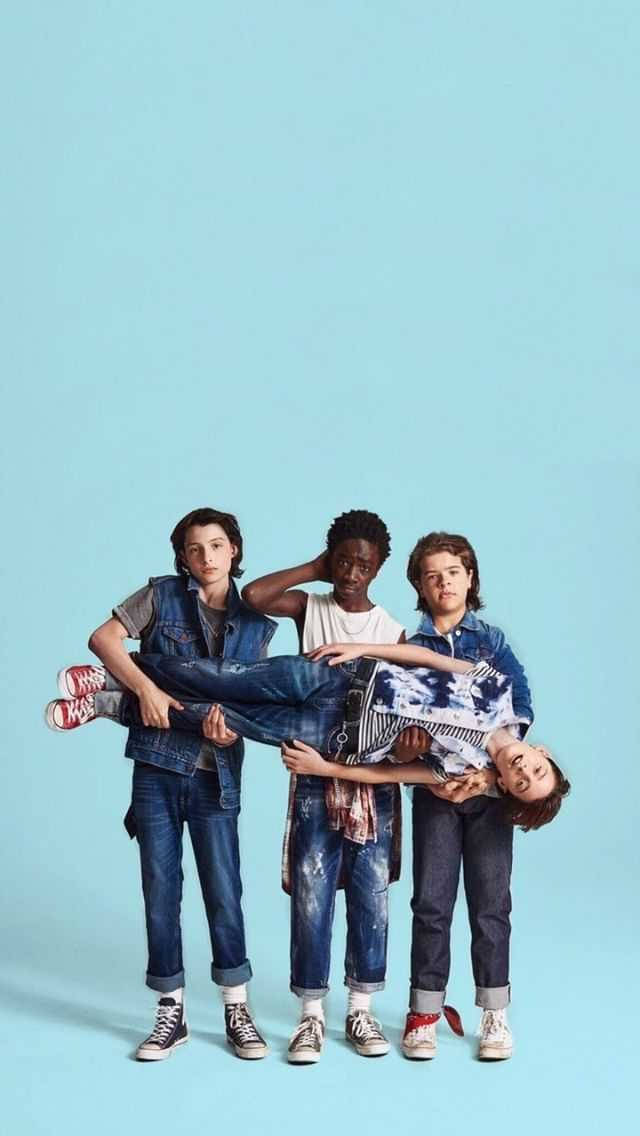Stranger Things Aesthetic 桌布 壁紙 — 四位穿著牛仔服裝的年輕朋友水平抬起第五位朋友，背景為純淺藍色。