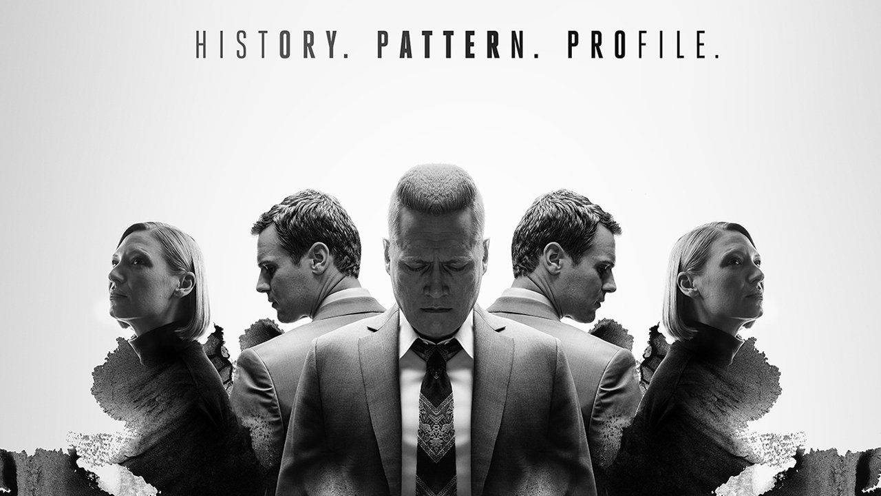 Entertainment 桌布 壁紙 — 四位穿著西裝的嚴肅專業人士以對稱線條排列，上方帶有文字的單色肖像。