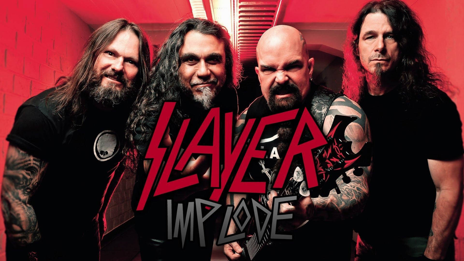 Slayer 桌布 壁紙 — 四位紋身金屬樂隊成員表情強烈，站在紅磚牆前，牆上以粗體紅色和灰色文字寫有樂隊名稱 Slayer 和專輯名稱 implode。