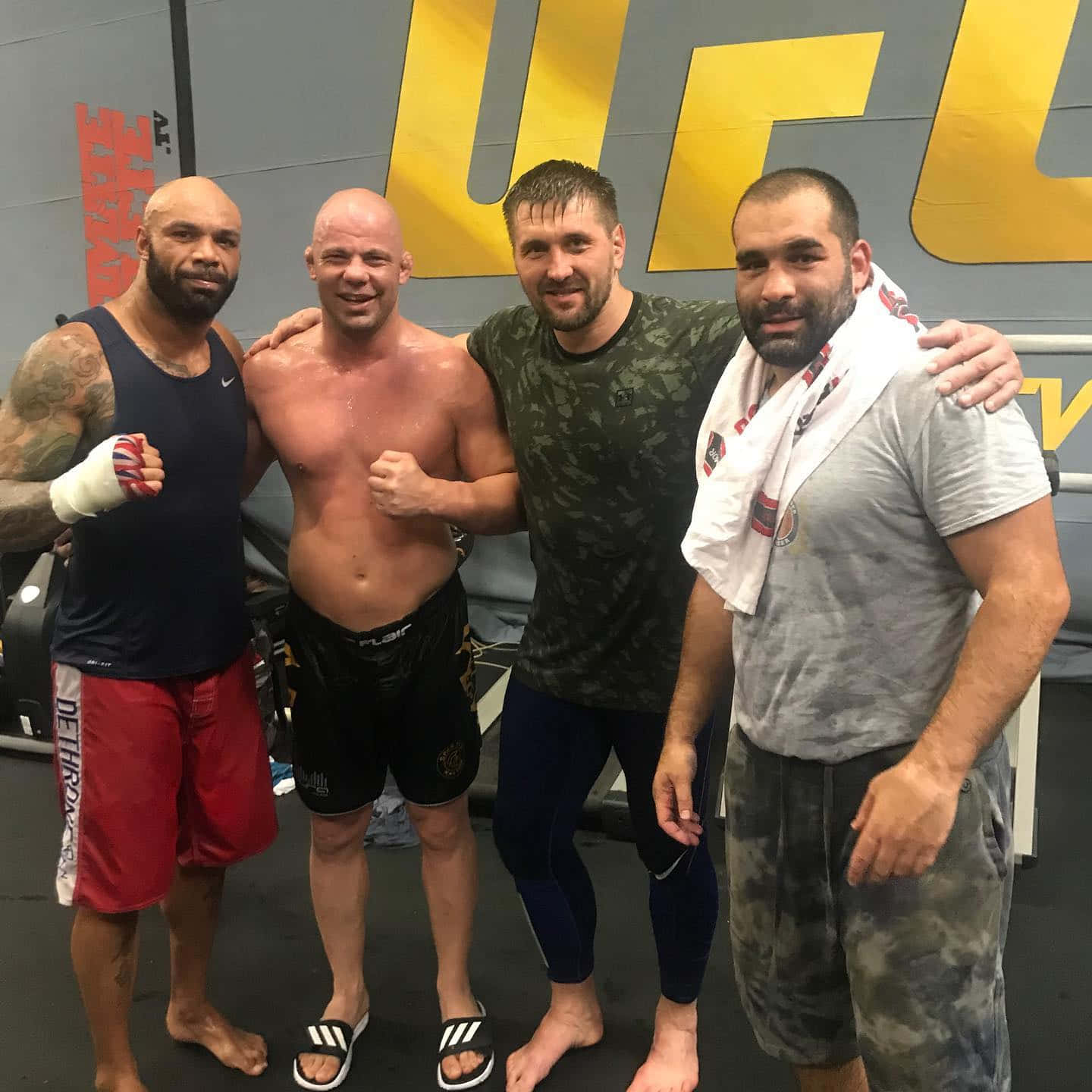 MMA 桌布 壁紙 — 四位肌肉發達的男性拳手在UFC健身房訓練後，滿身汗水、面帶笑容一起擺姿勢。