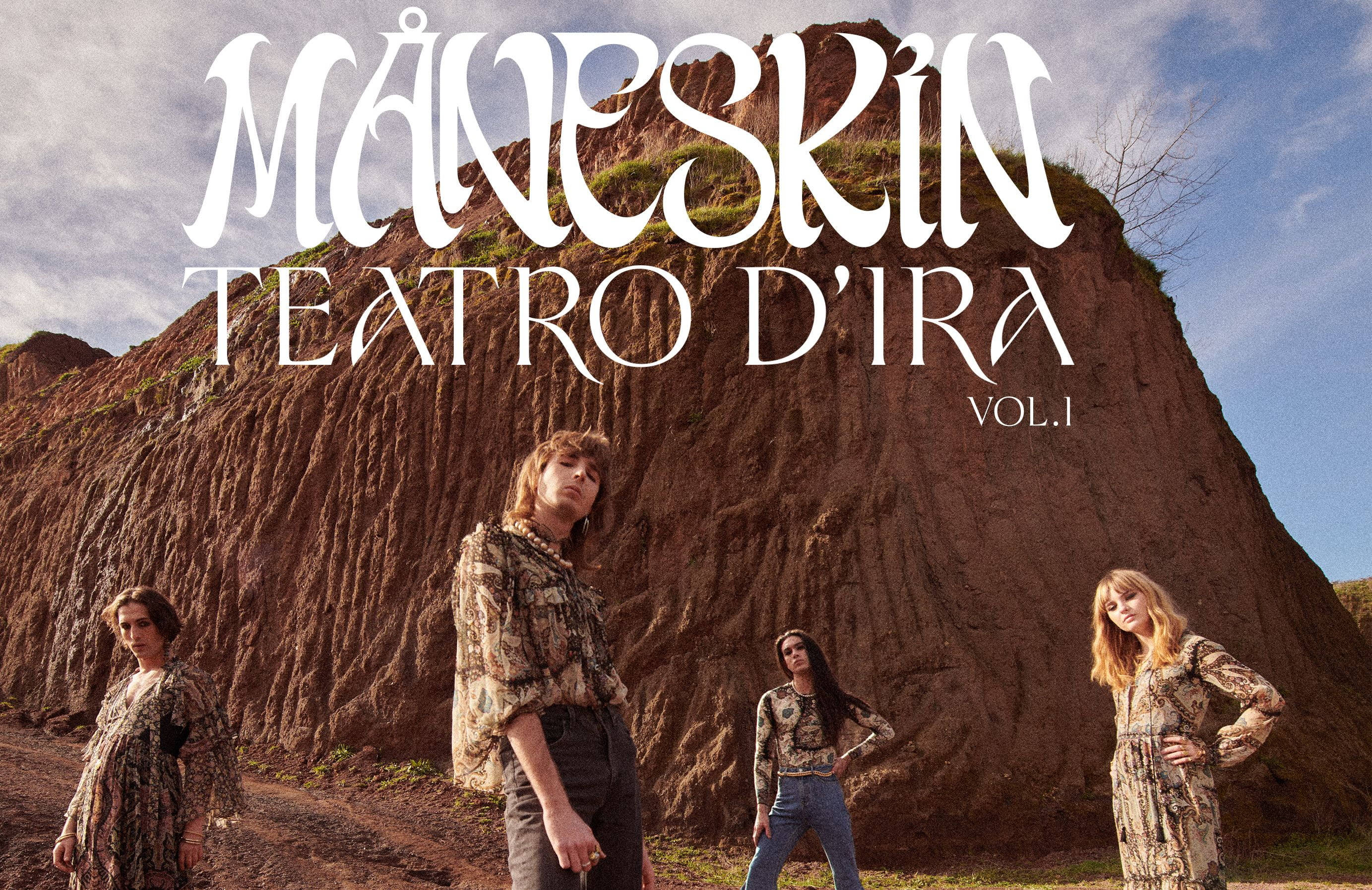 Maneskin 桌布 壁紙 — 四位身穿圖案服裝的樂隊成員站在崎嶇的土崖前，天空多雲，並有粗體白色文字疊加。