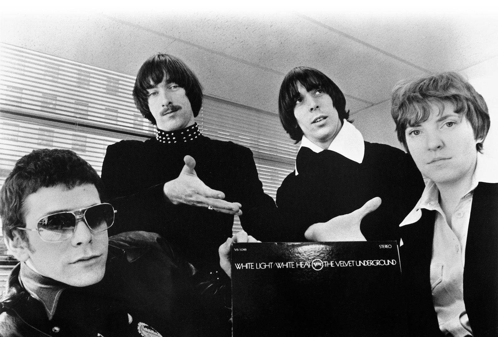 band 桌布 壁紙 — 四位身穿黑衣的男士在光線強烈的室內環境中，與 Velvet Underground 專輯封面合影。