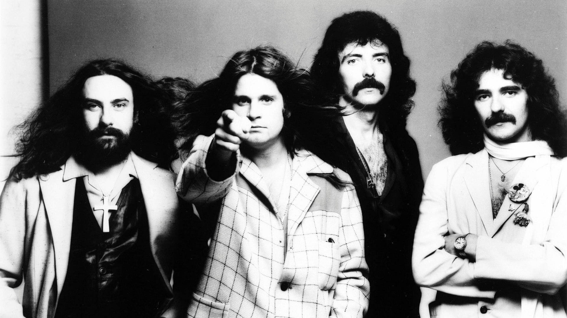 Ozzy Osbourne 桌布 壁紙 — 四位長髮留鬍子的男子在黑白工作室肖像中強烈擺姿勢，其中一位直接指向觀看者。