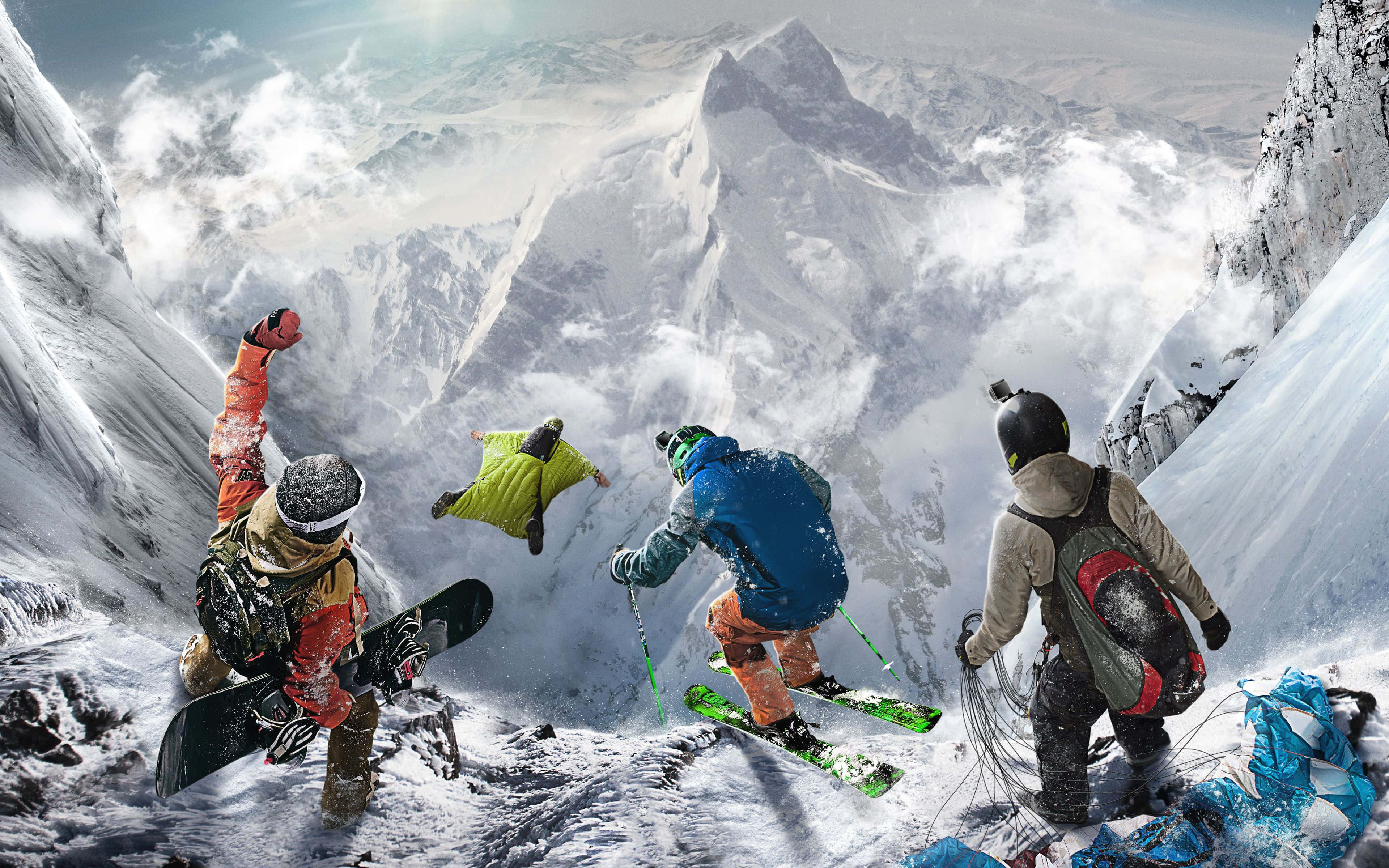 Snowboarding 桌布 壁紙 — 四位雪地冒險家在山頂慶祝，其中一人穿著翼裝翱翔。