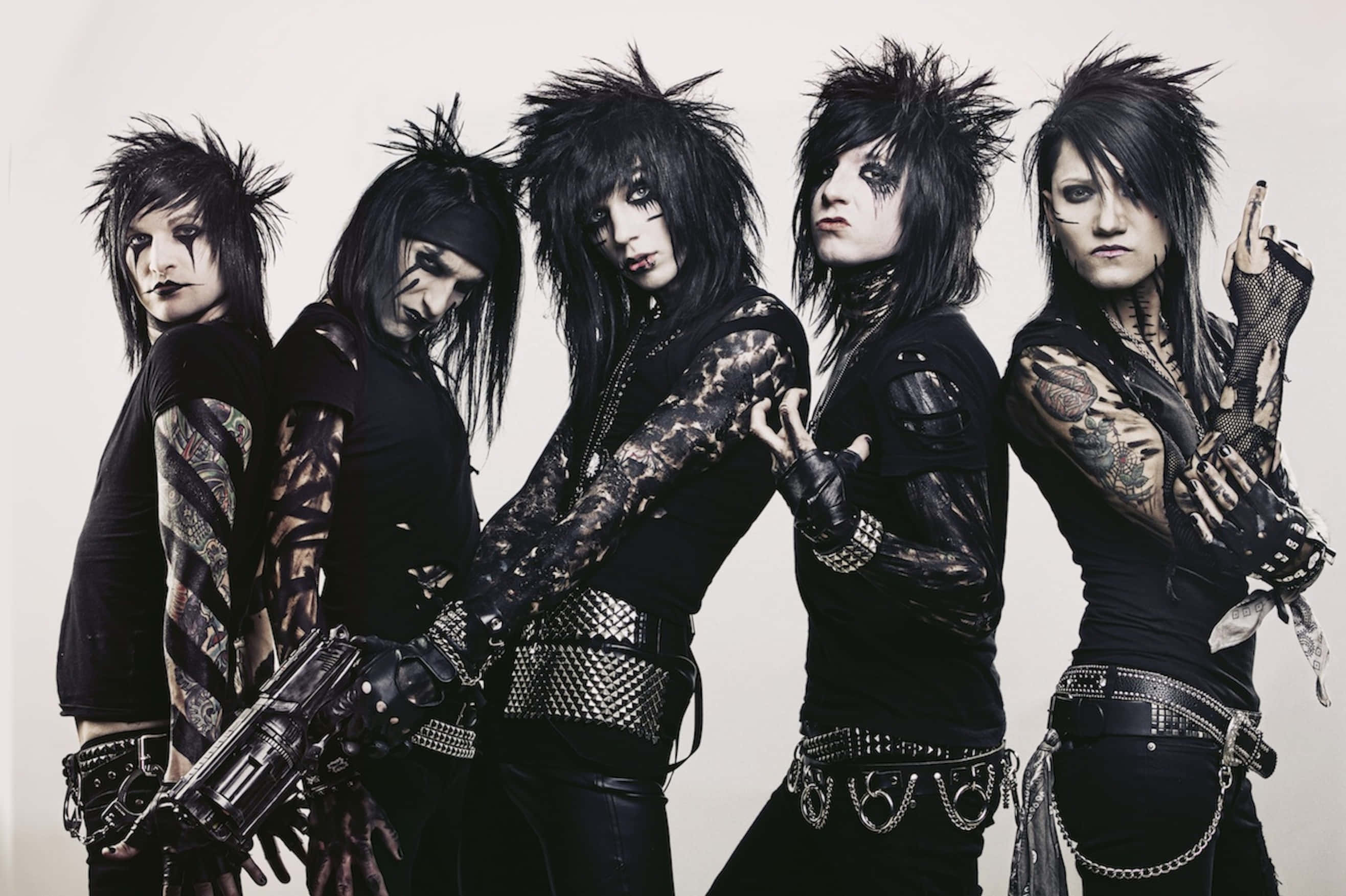 Black Veil Brides 桌布 壁紙 — 四位龐克搖滾樂手，擁有尖刺黑髮、刺青和鉚釘皮革裝備，在純色背景前強烈擺姿勢。