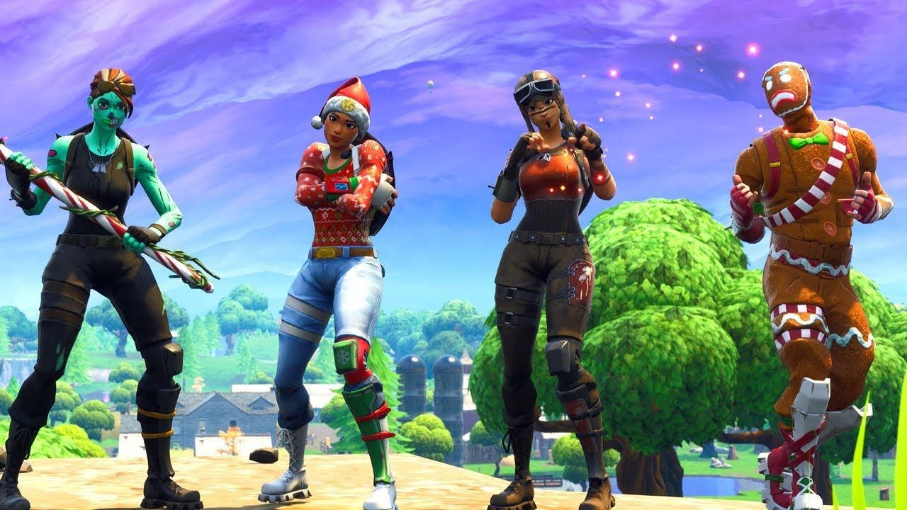 Og 桌布 壁紙 — 四個 Fortnite 角色穿著節日服裝，在充滿活力的紫色天空和綠色景觀前愉快地擺姿勢。