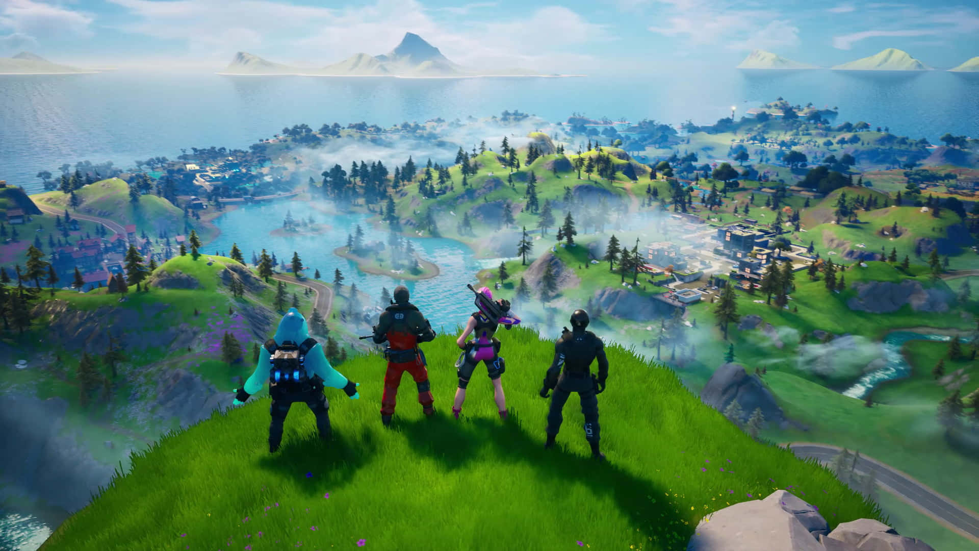 Xbox Games 桌布 壁紙 — 四個Fortnite角色站在一個長滿草的懸崖上，俯瞰著一個廣闊的島嶼，島上有湖泊、森林和遠處的山脈，天空湛藍。