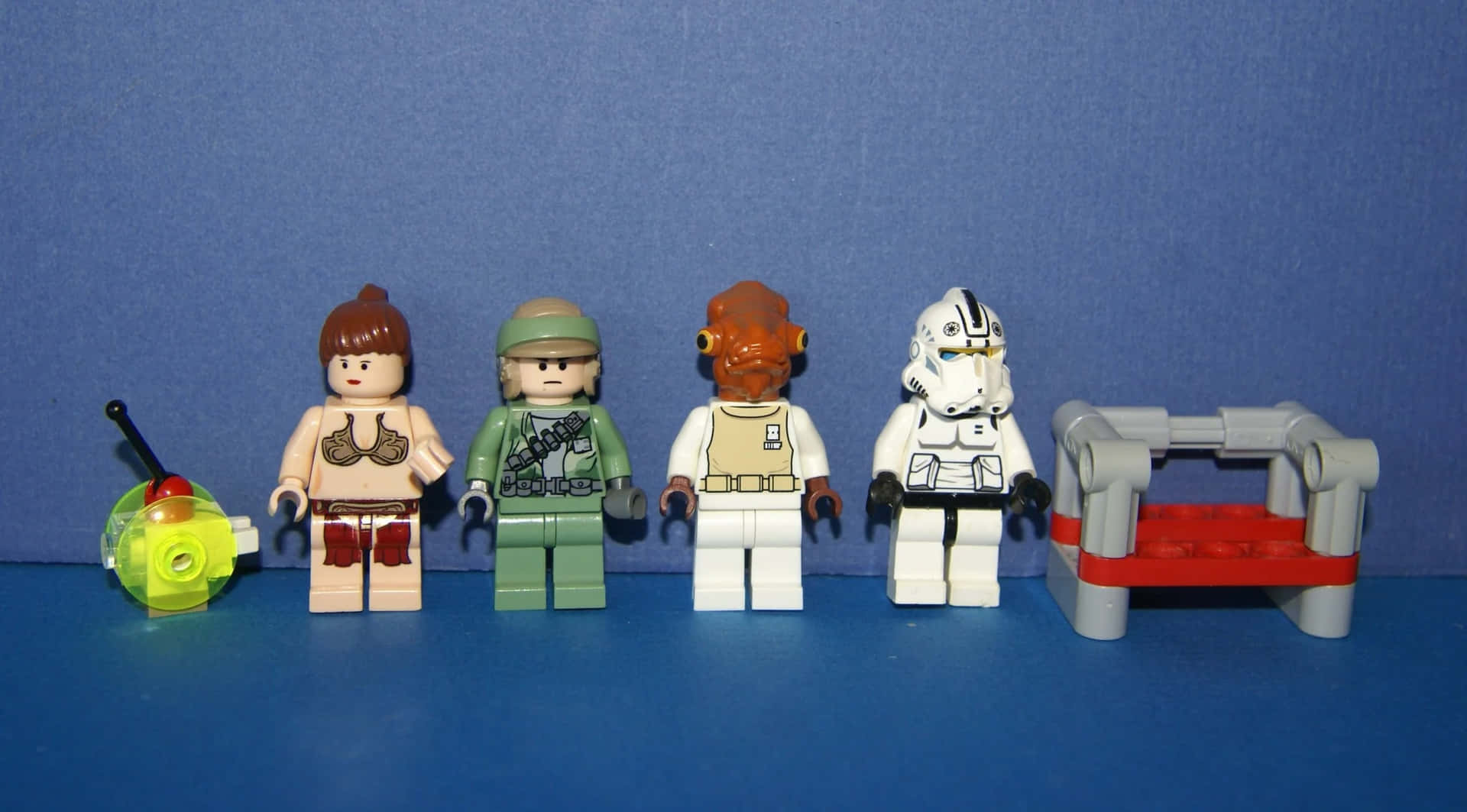 Admiral Ackbar 桌布 壁紙 — 四個LEGO Star Wars人偶和一個小長凳在純藍色背景前一字排開。