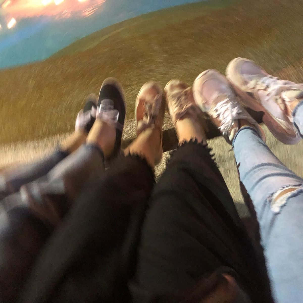 Friends 桌布 壁紙 — 四個人的腳穿著不同的鞋子和牛仔褲，一起站在草地上，頭頂是色彩繽紛的暮色天空。