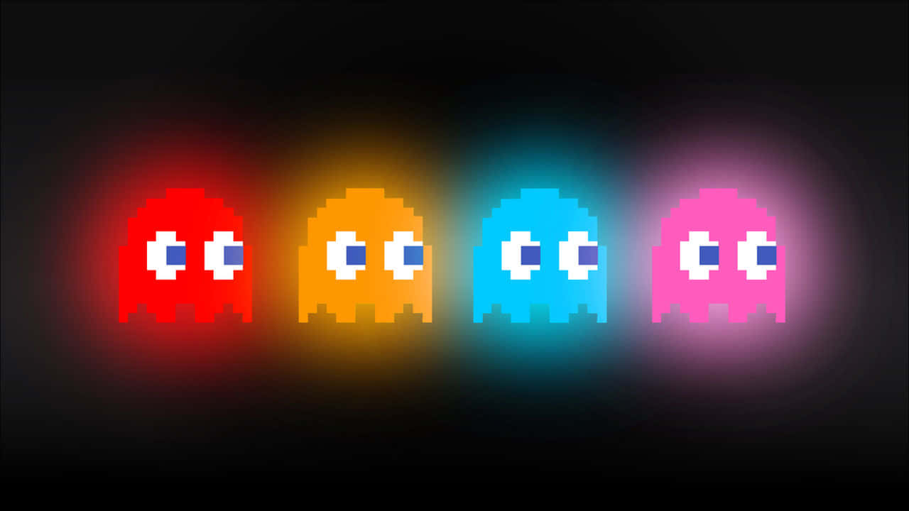 Pacman 桌布 壁紙 — 四個來自 Pac-Man 的發光像素鬼魂在黑暗背景下散發出鮮豔的紅色、橙色、藍色和粉紅色。
