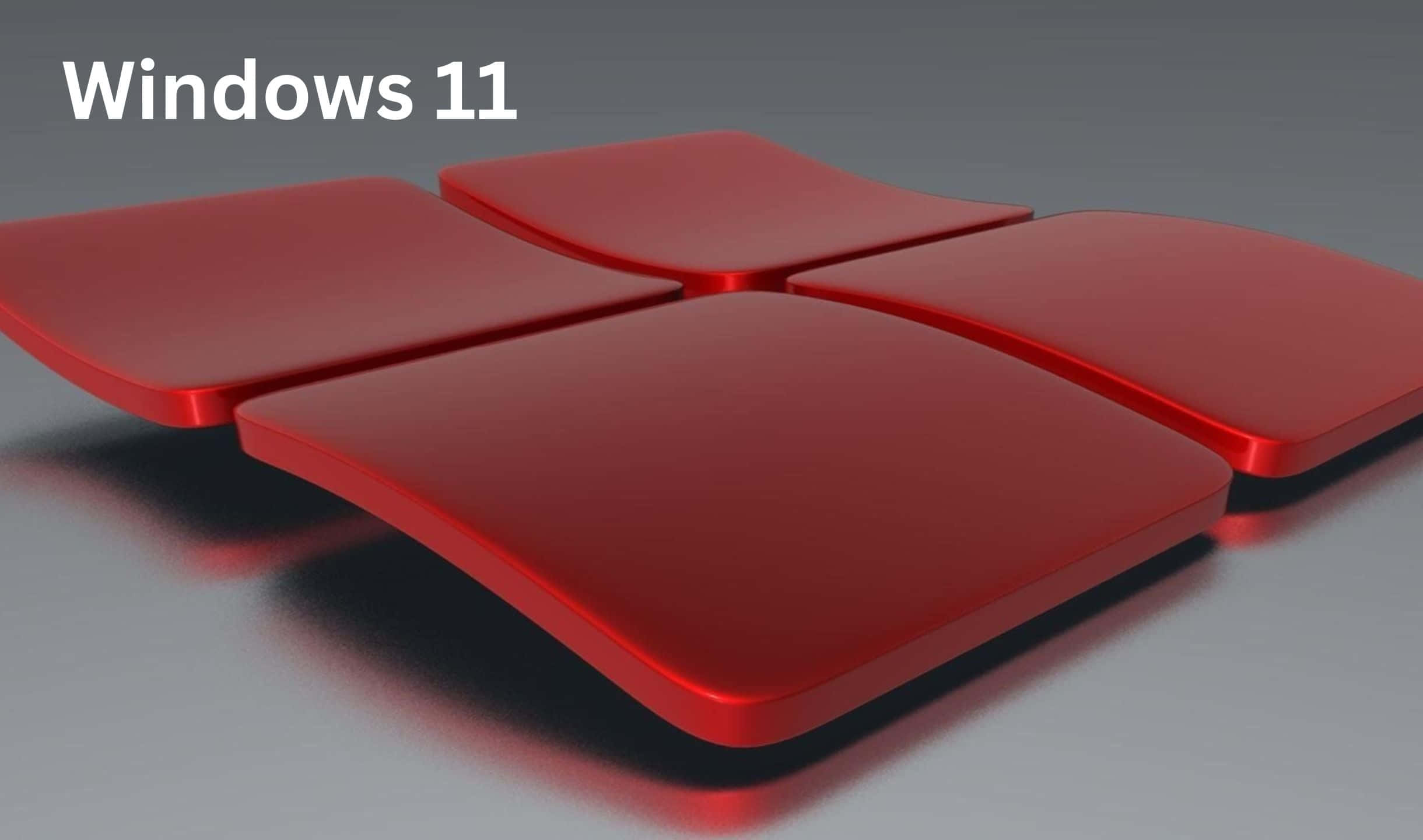 Windows 11 桌布 壁紙 — 四個光滑的紅色圓角正方形排列成窗戶標誌形狀，位於灰色表面上，帶有柔和陰影。