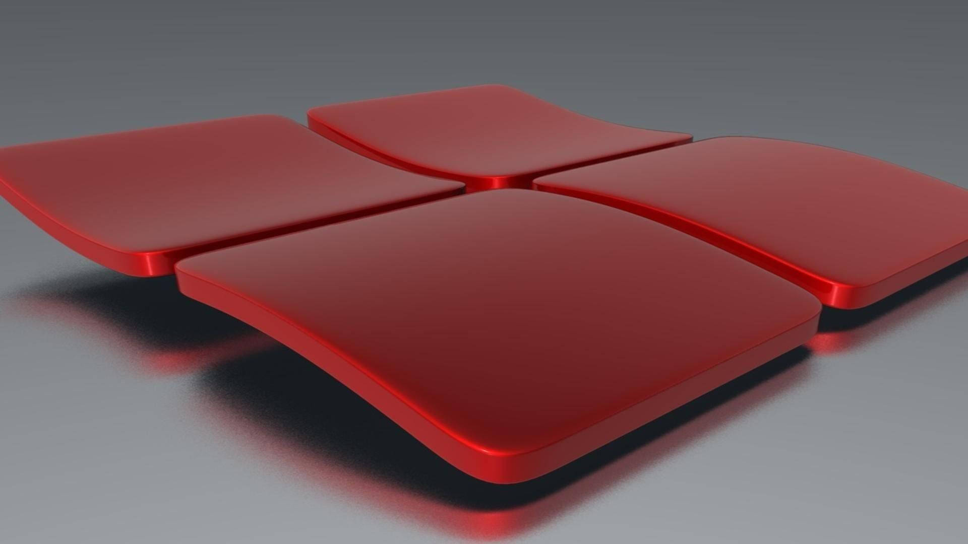 Windows 11 桌布 壁紙 — 四個光澤紅色弧形面板以十字形排列在灰色表面上，帶有柔和陰影。