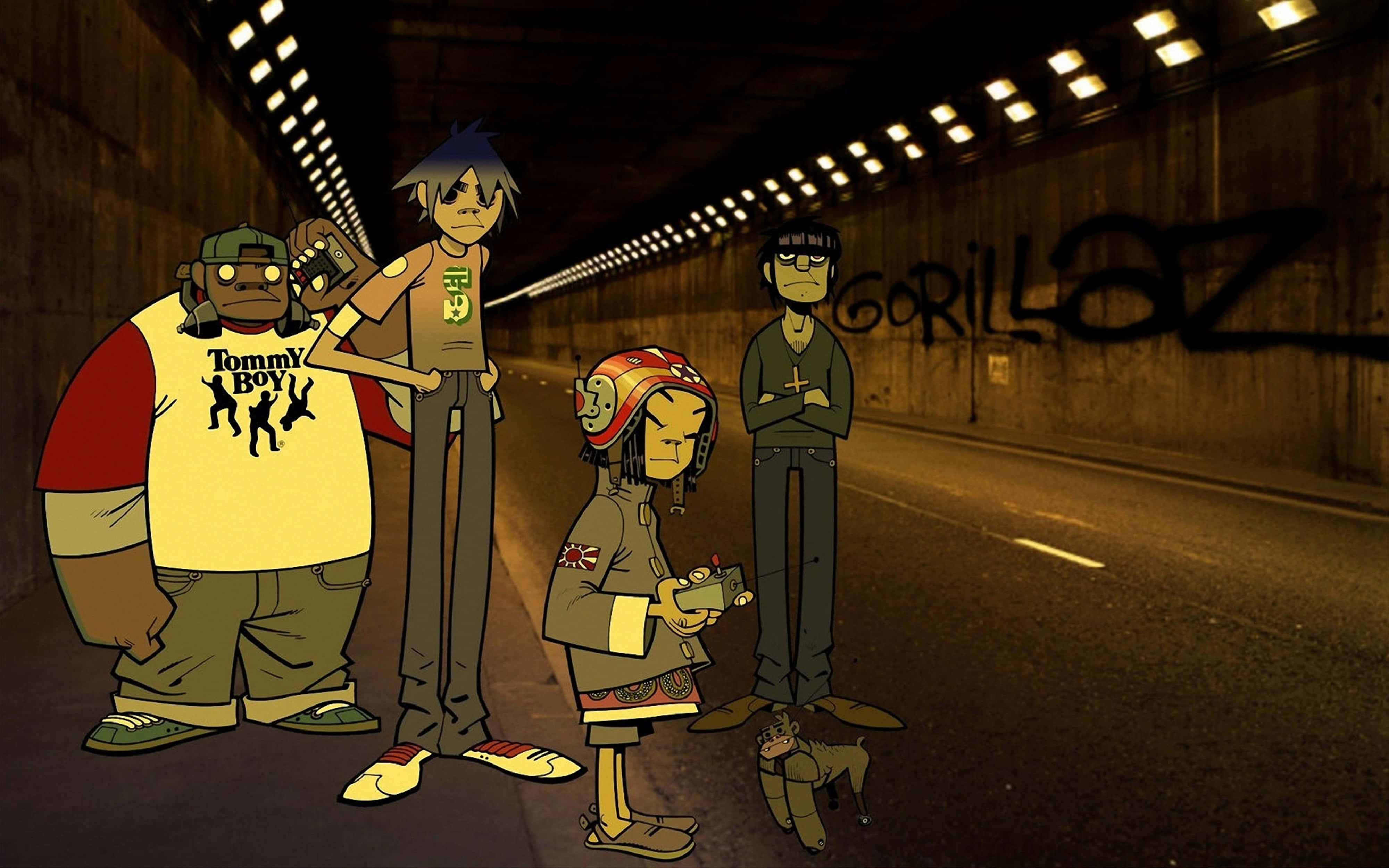 音樂 桌布 壁紙 — 四個動畫化的Gorillaz樂團成員站在一個光線昏暗的城市隧道中，牆上有塗鴉。
