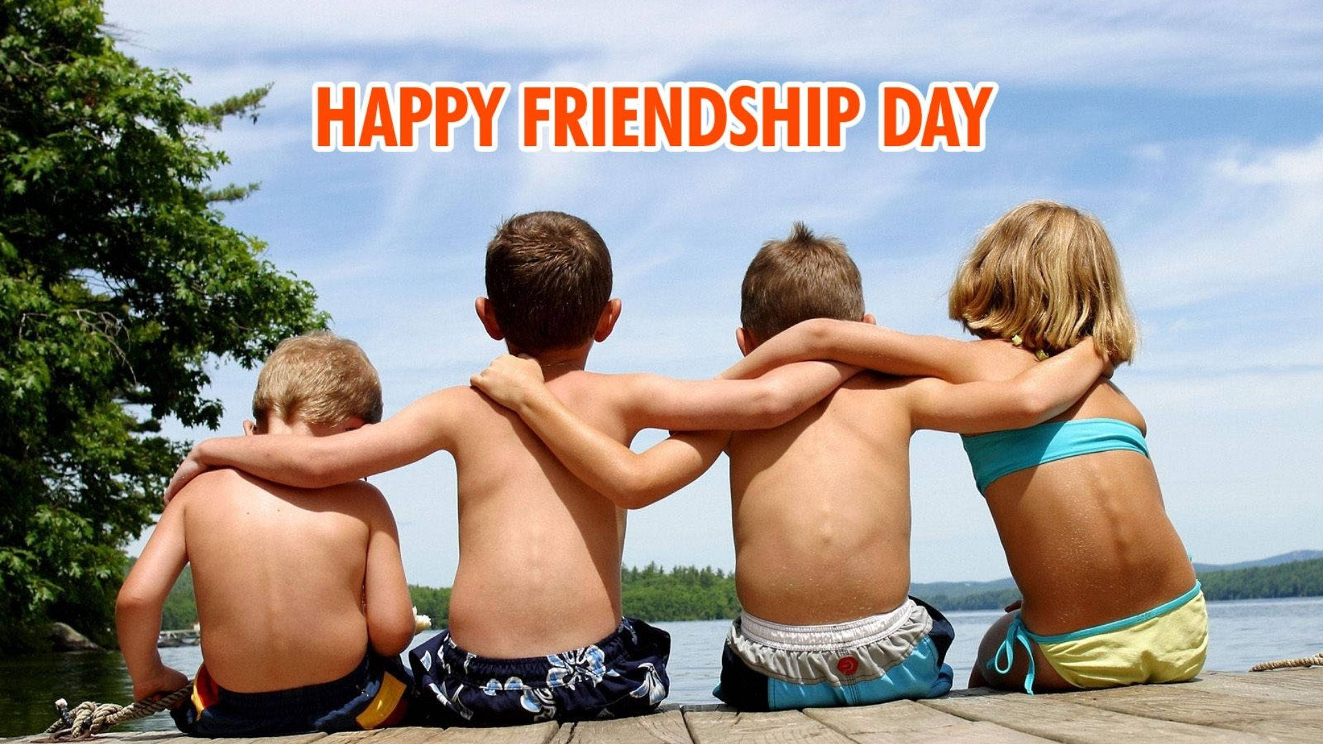 Friendship Day 桌布 壁紙 — 四個孩子背對背坐在湖邊的碼頭上，手臂相連，頭頂是明亮的藍天。